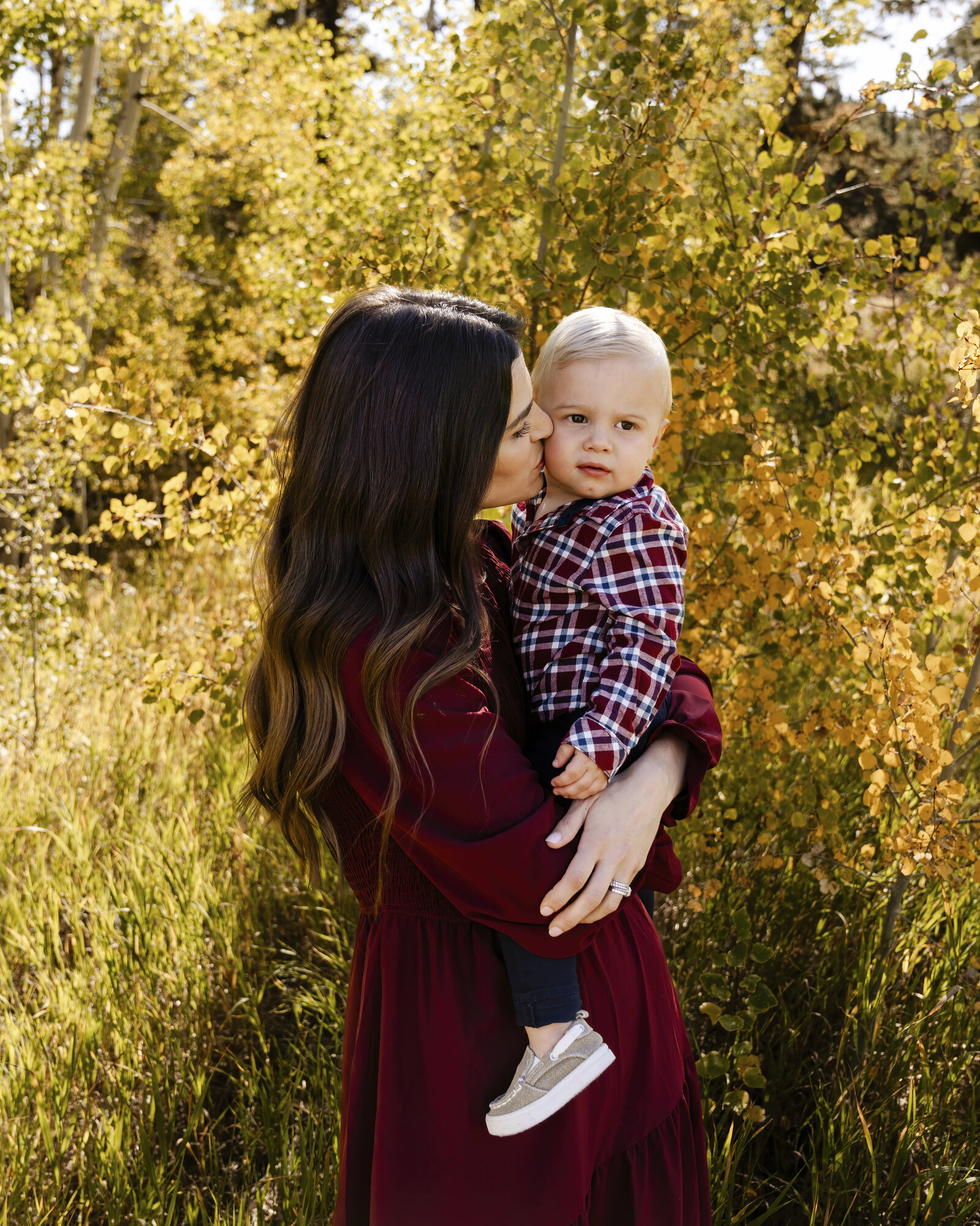 mom kissing son on cheek