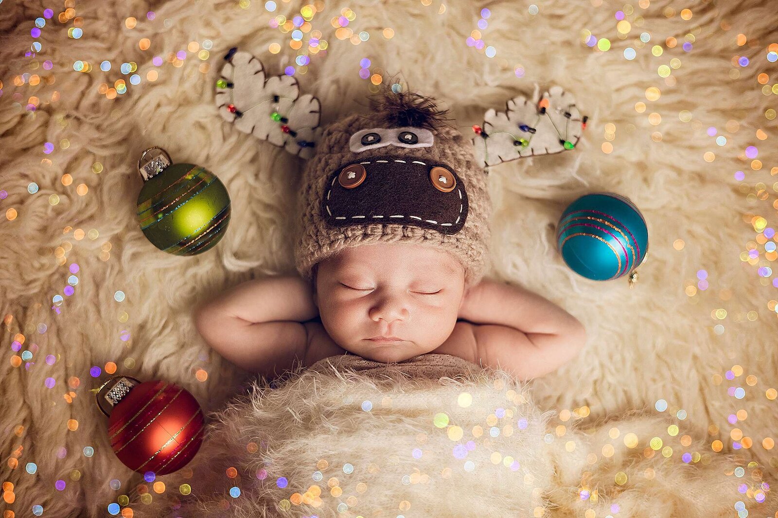 A sleeping newborn baby in a cute moose hat rests on a blanket, beautifully captured by Bia Schaefer Photography in Orlando.