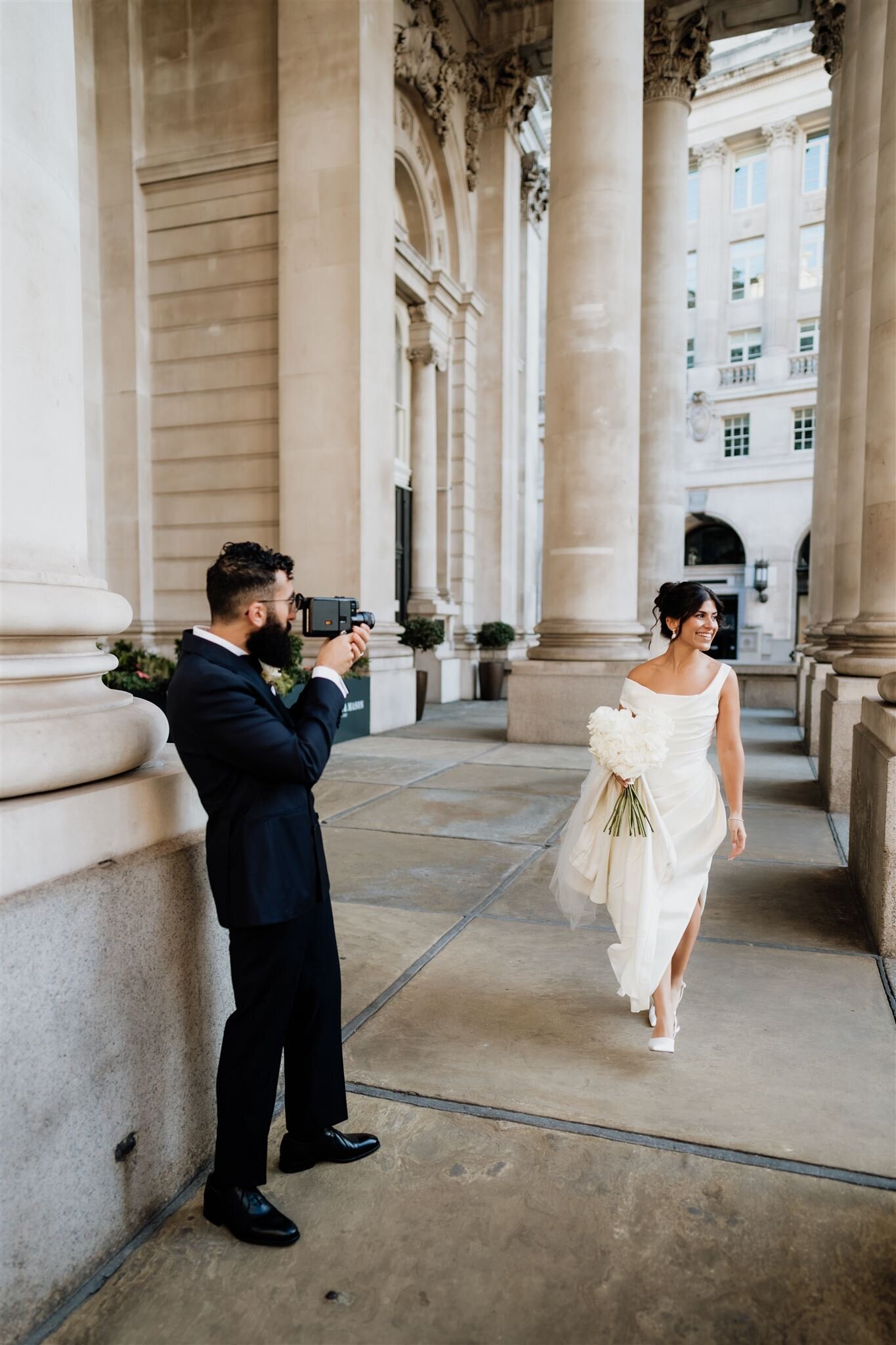 groom filming bride on super8 camera for their wedding portaits in London