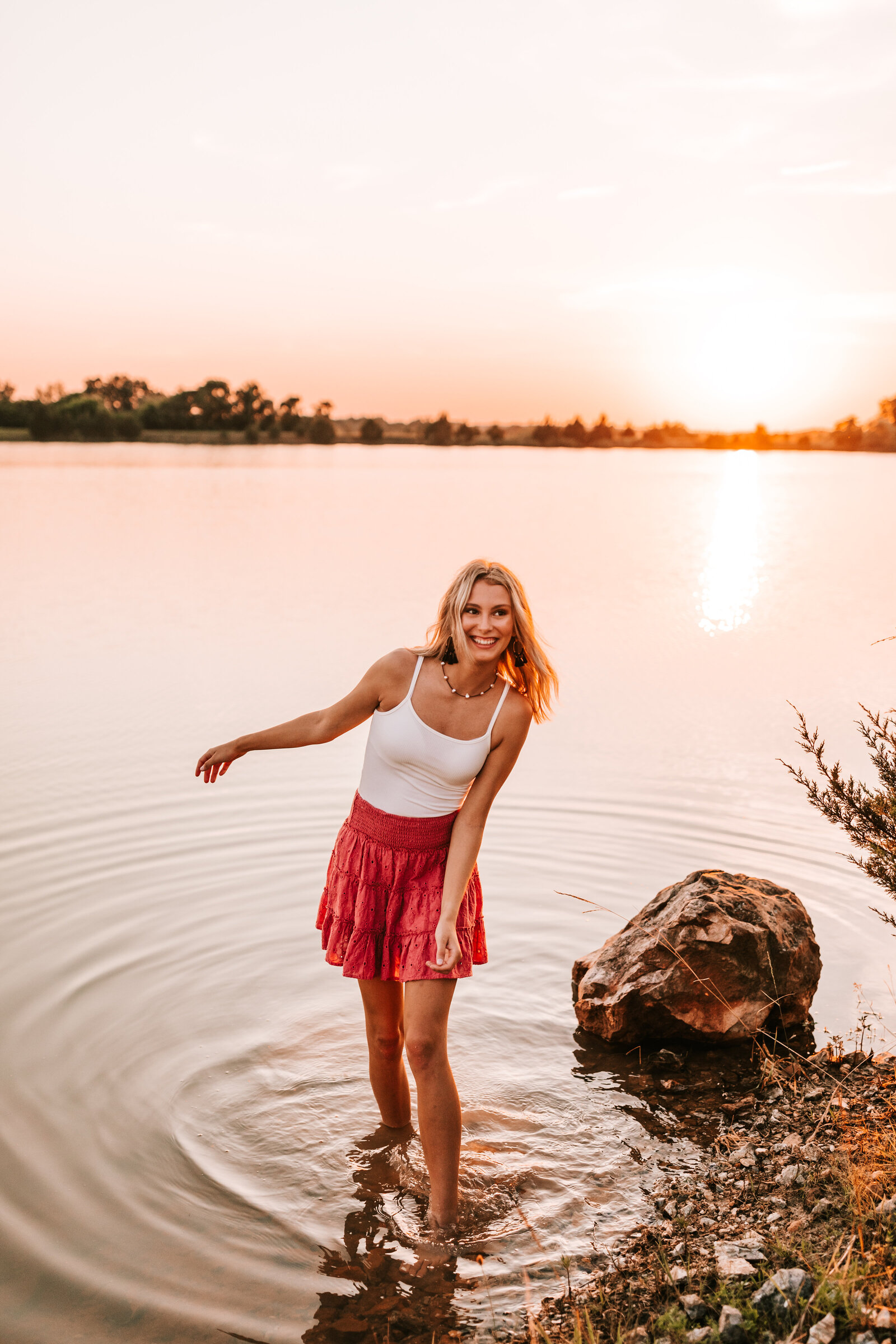 senior standing in a pool of water with feet in the water at sunset senior girl 2022