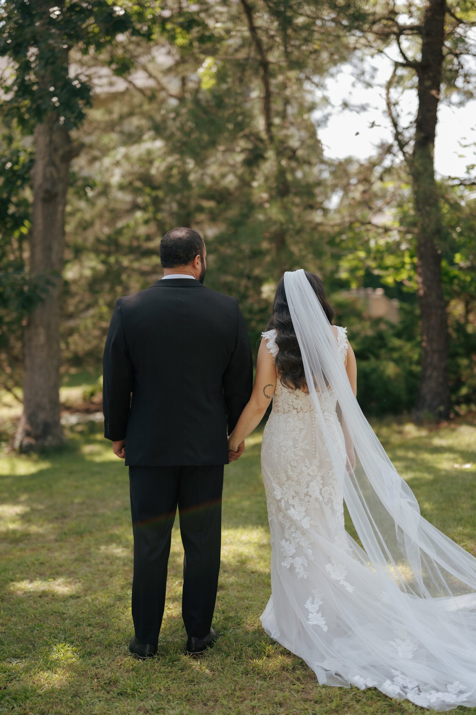 The back of the groom and bride at their outdoor wedding venue in New York | Emma LeeAnn Photography