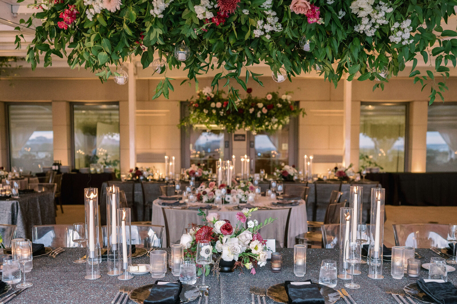 A Virginia Wedding features white and burgundy flowers on a silver table cloth with tall white candles