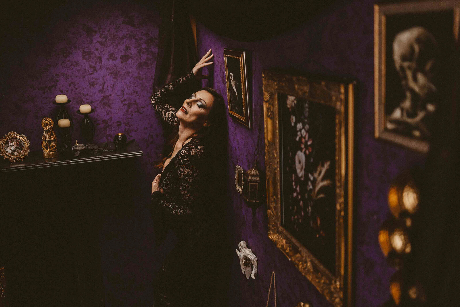 spooky looking woman in purple wall of paintings
