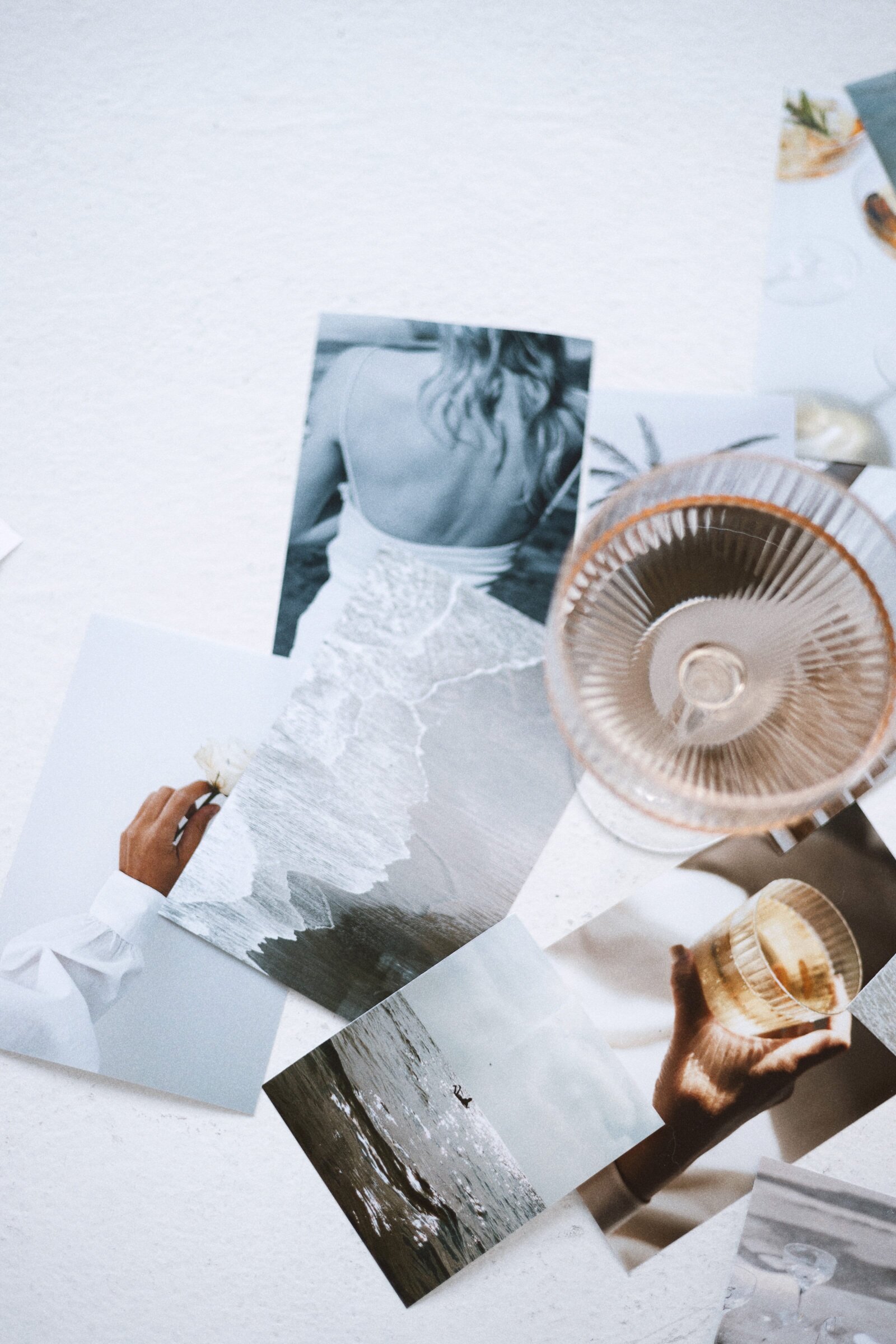 Pictures artfully arranged on the floor, accompanied by a glass of champagne, creating a stylish and captivating ambiance for brand styling.