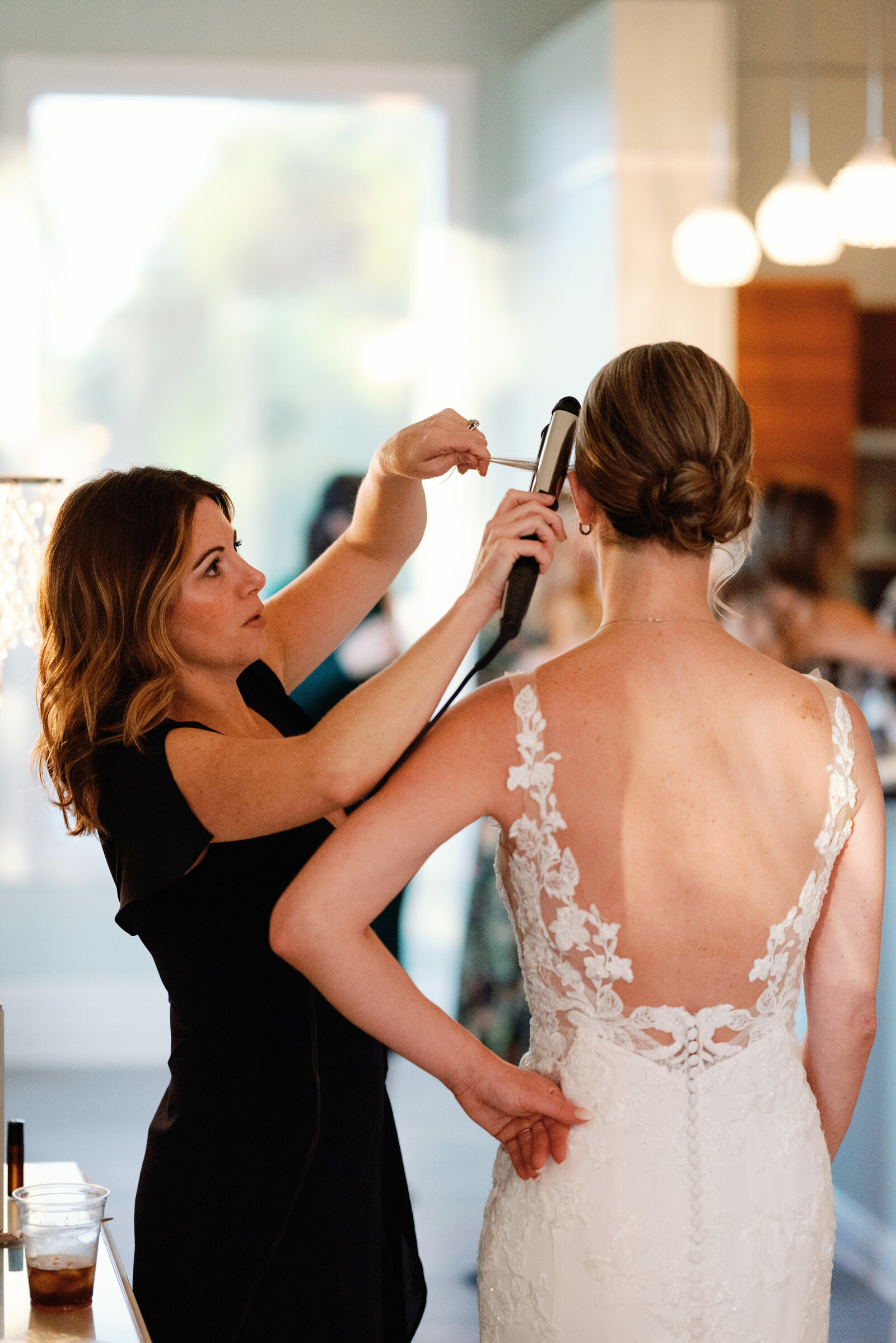 bride getting her hair touched up before the wedding ceremony begins