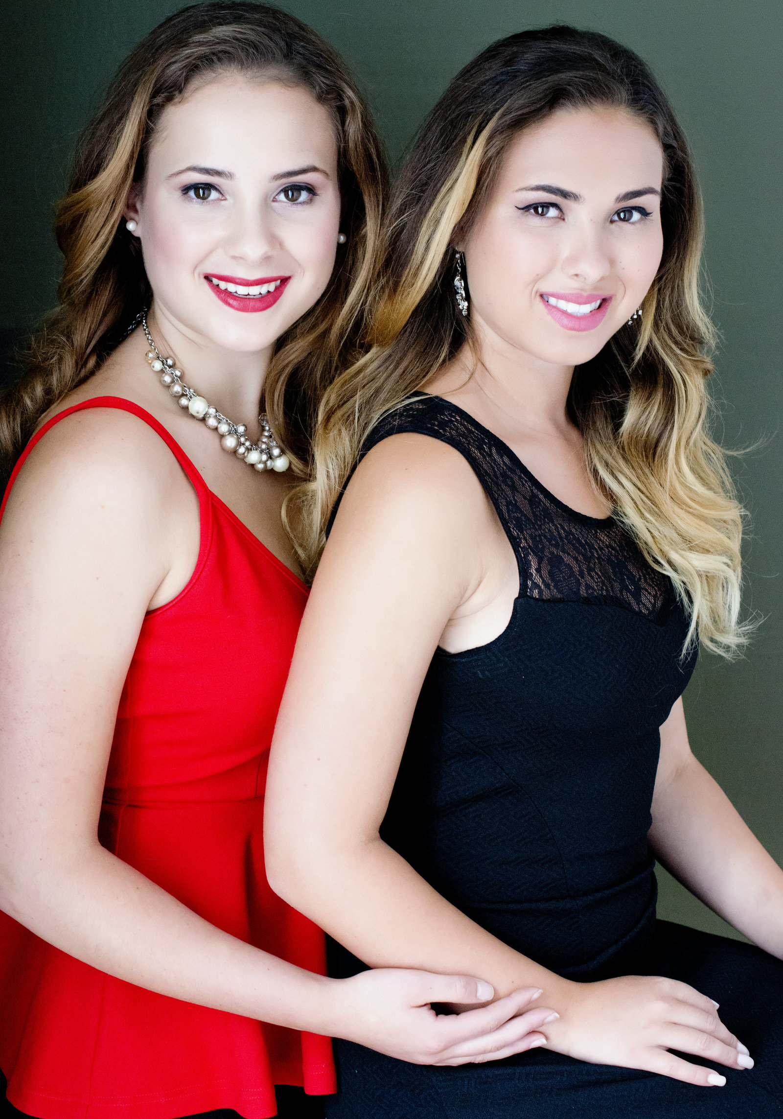 REALTOR Portrait of  two sisters  Photography  wearing black and  red dress holding hands
