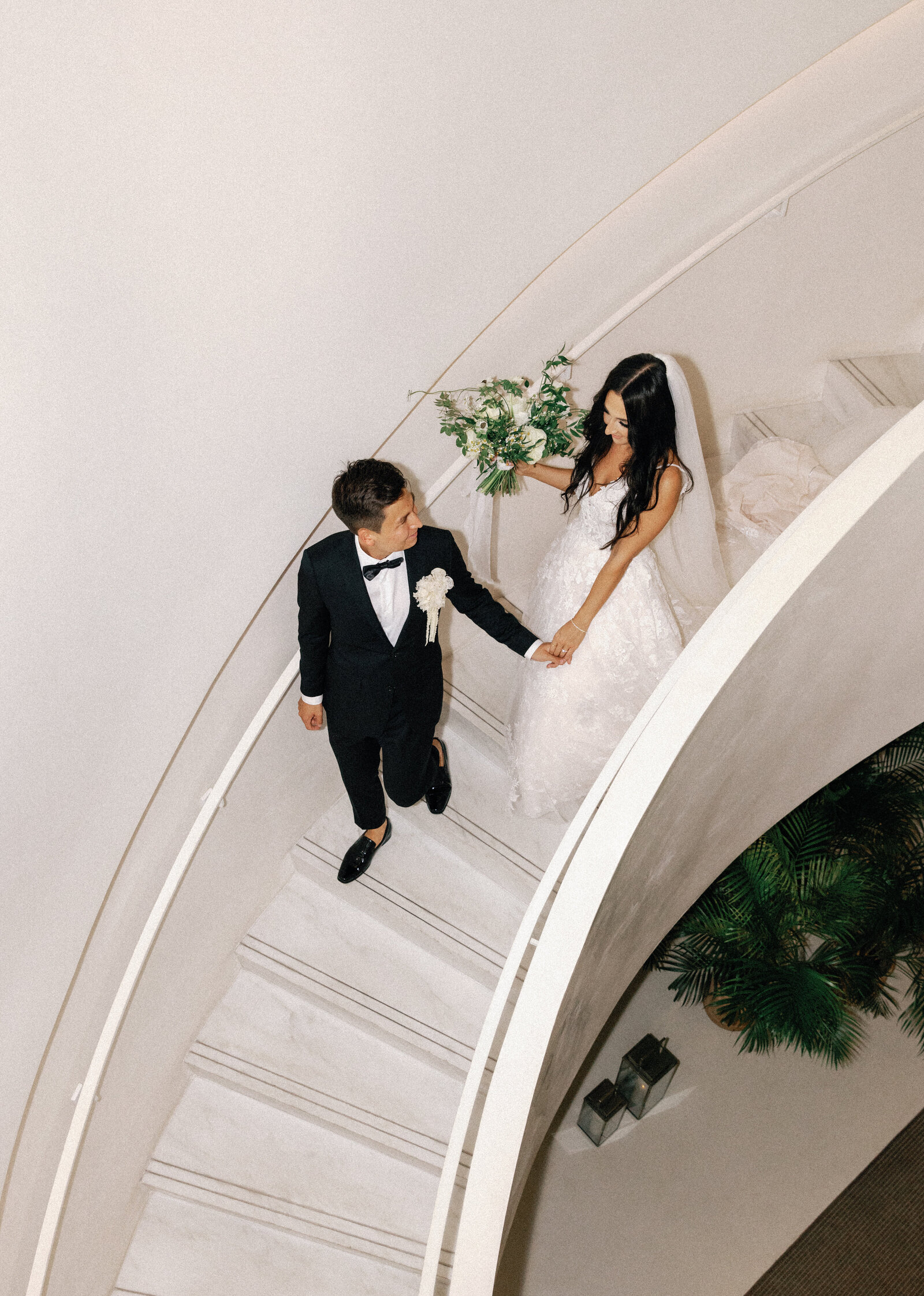 modern bride and groom walking down stairs