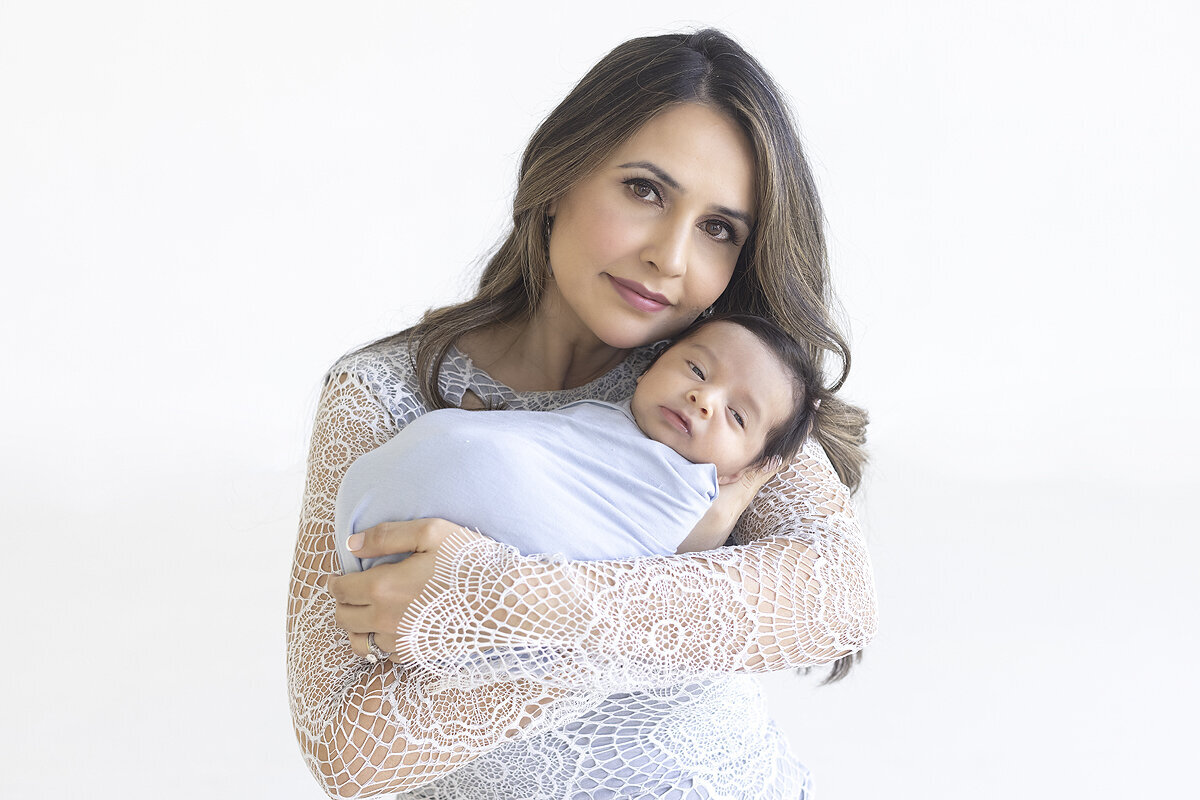 New mother holding newborn son, a Dallas newborn photographer.