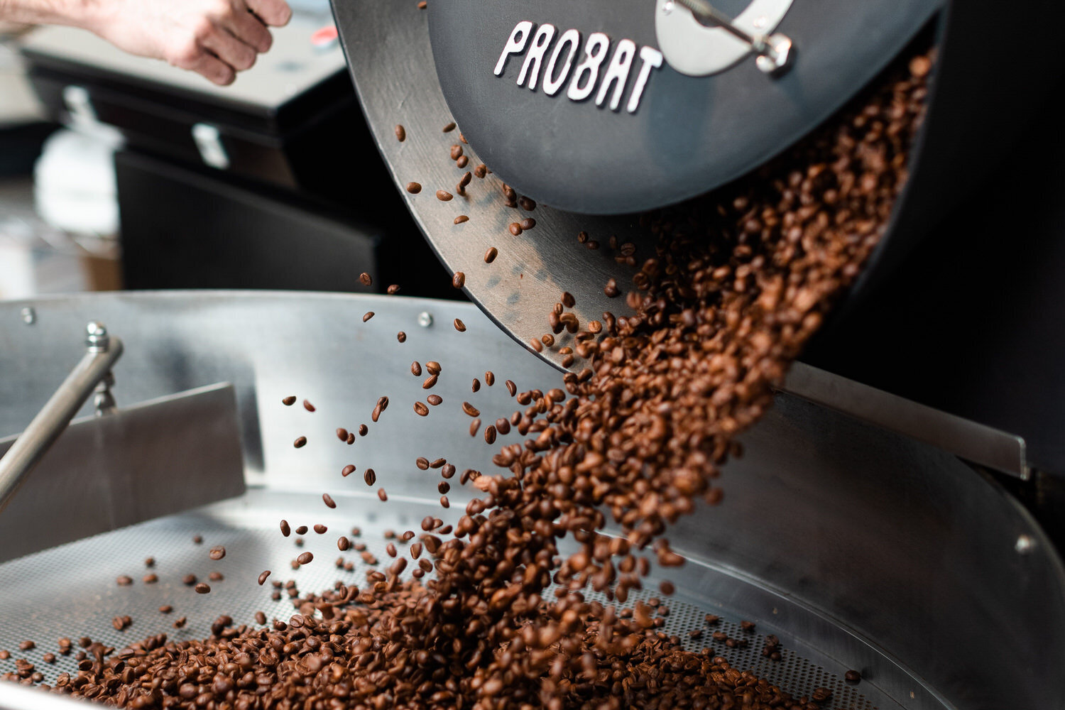 coffee beans being poured into a grinder