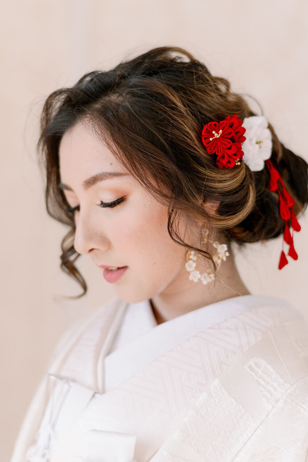 Close-up of bride in shiromuku with red floral hairpiece | 着物レンタル 和婚 白無垢 花嫁 ヘアアクセ