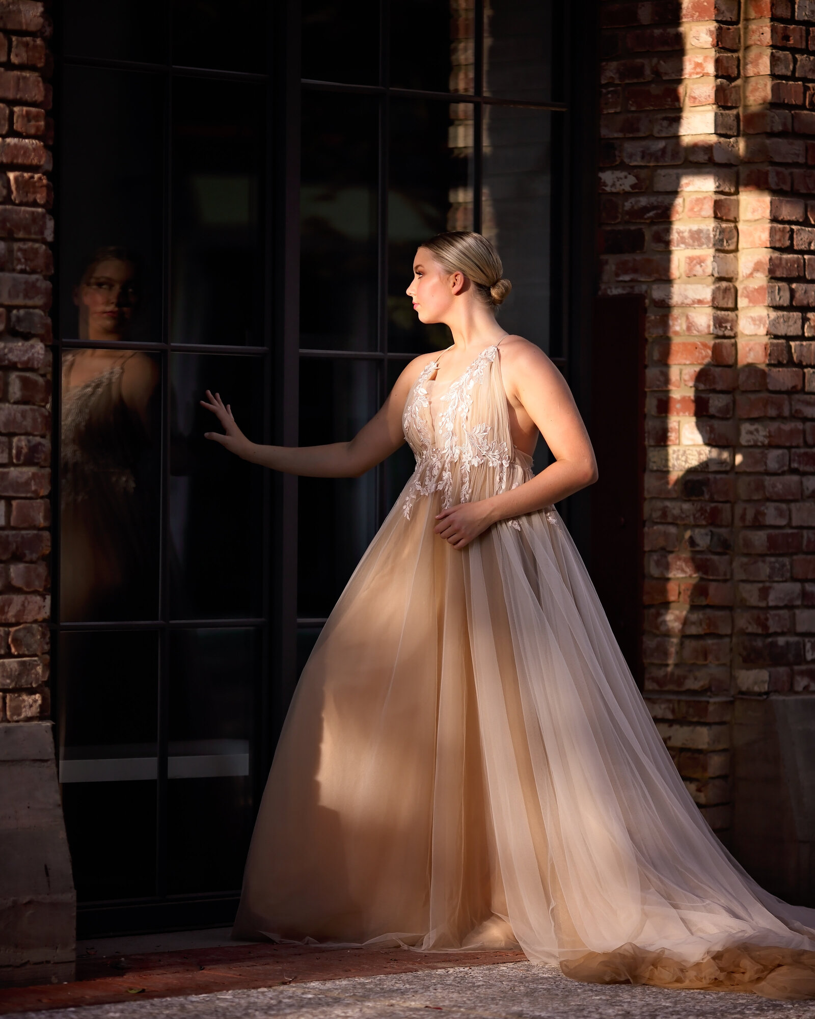 Savannah Boudoir Photography and Glamour showcases gorgeous blond dancer in flowing glamour gown relection in window
