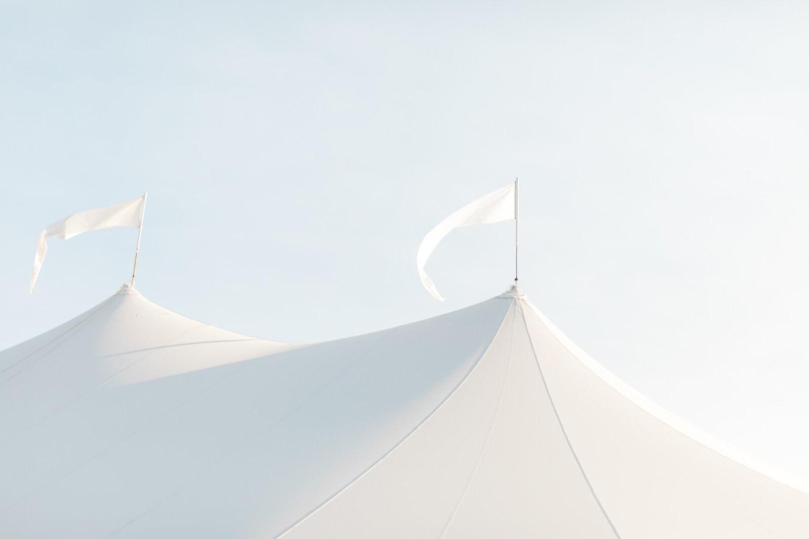 white reception tents against a light blue sky