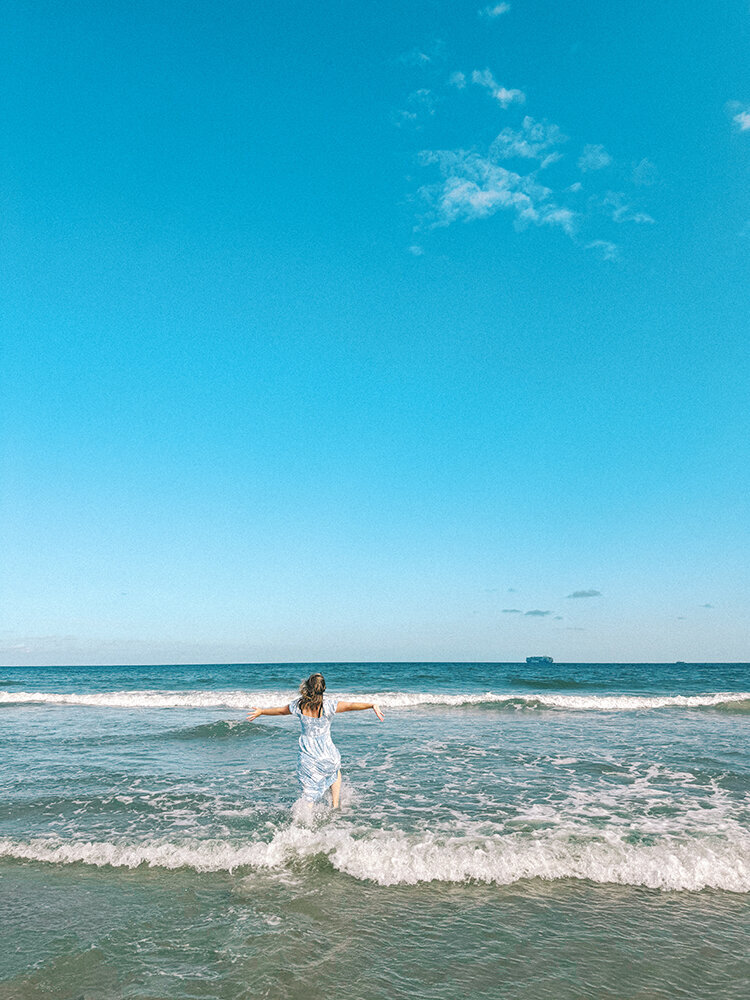 girl running into ocean