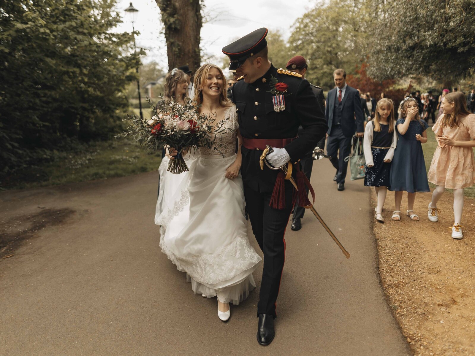 groom in uniform walking with bride