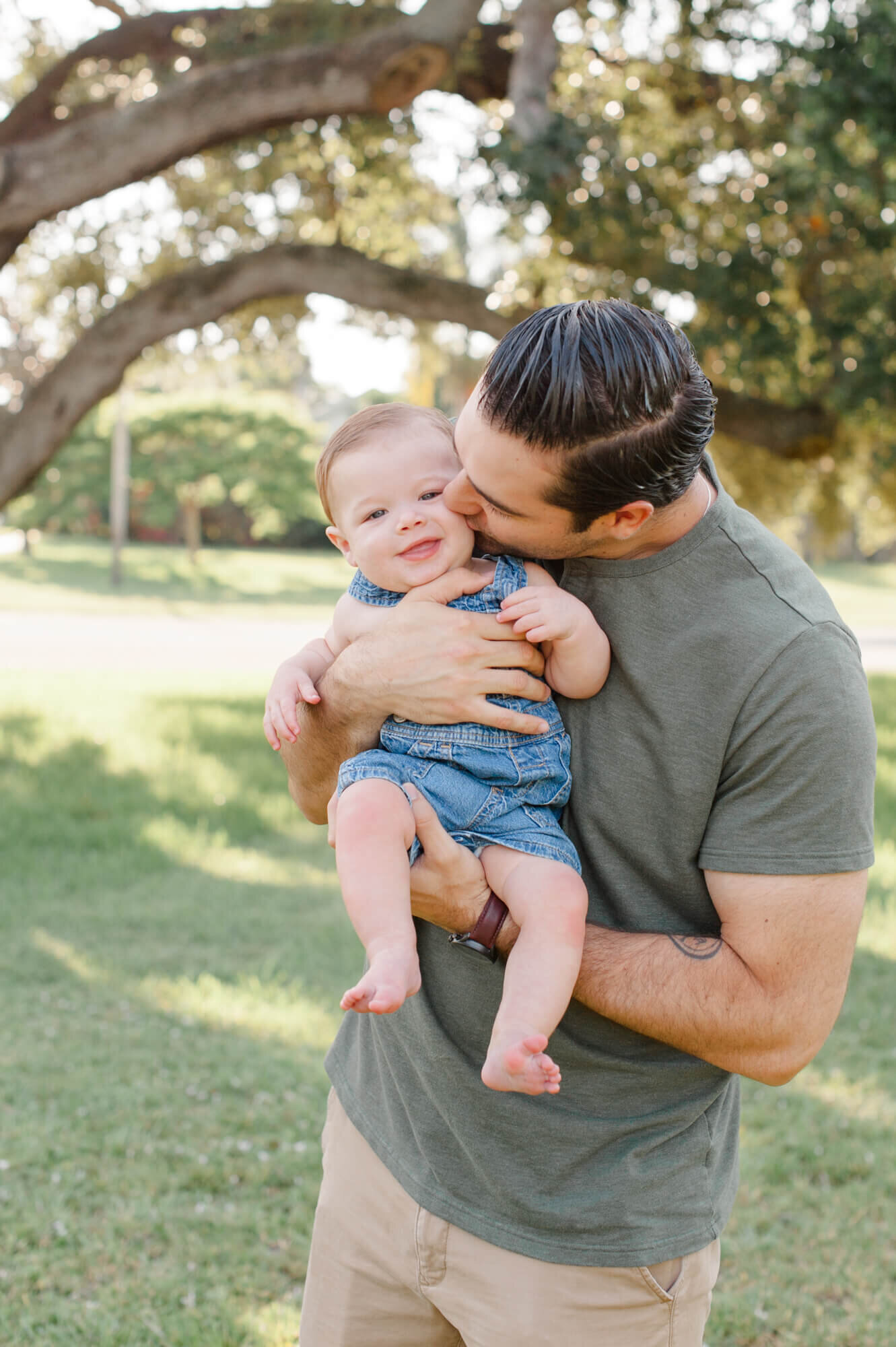 Dad holding son and kissing him on the cheek during their morning session