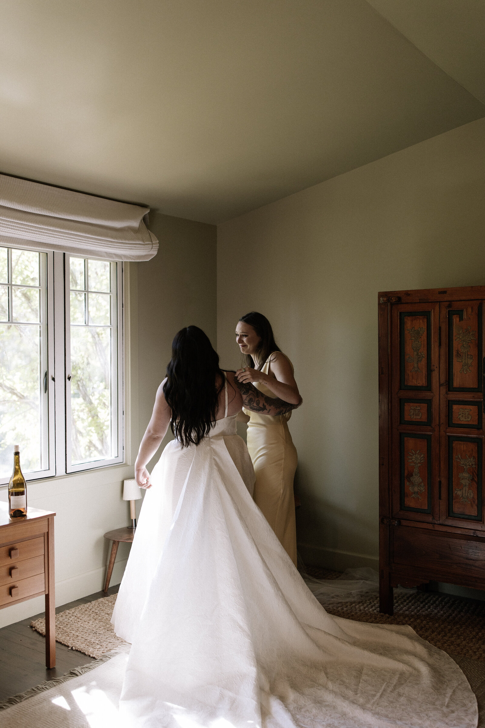 Bridesmaid hugs bride during first look taken by best Northern California wedding photographers