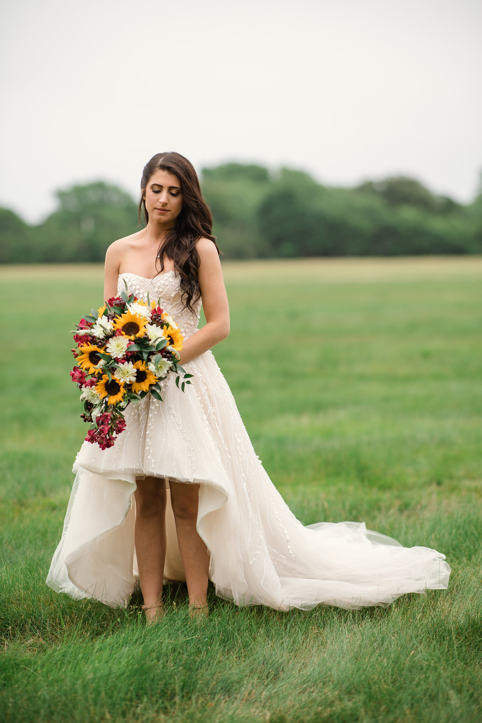 Bride holding her sun flower bouquet at the Bourne Mansion
