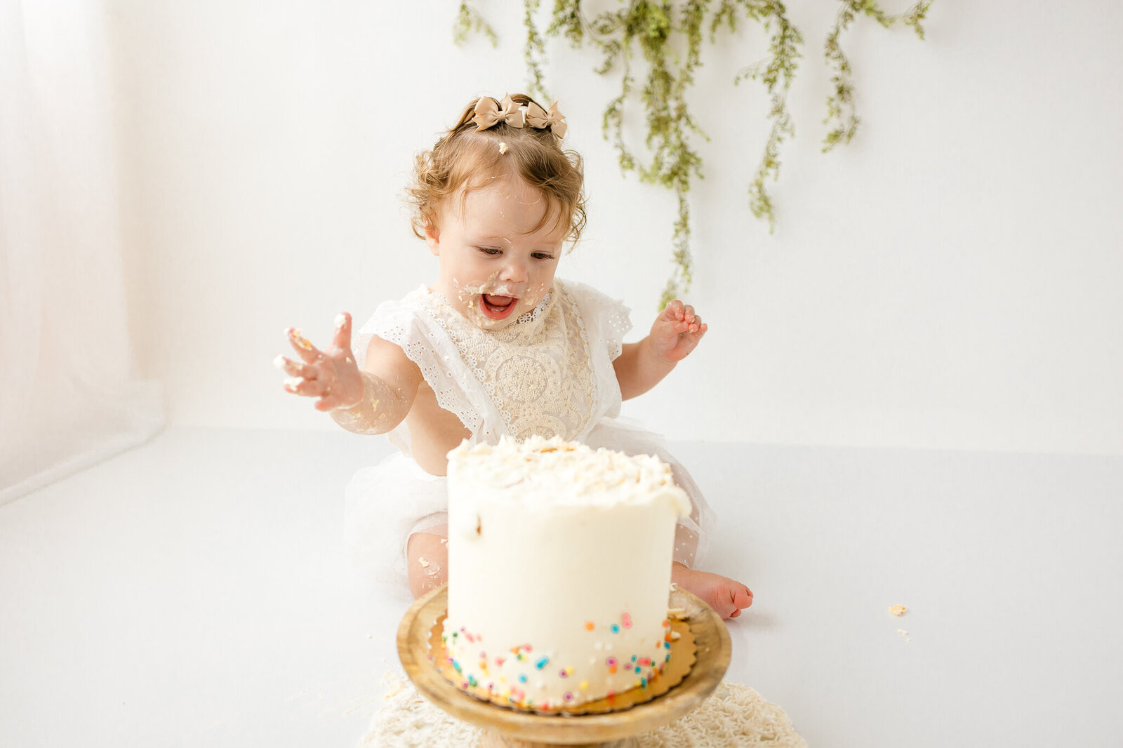 one year old girl surprised at her cake during her cake smash session in studio with Constance Calton photography