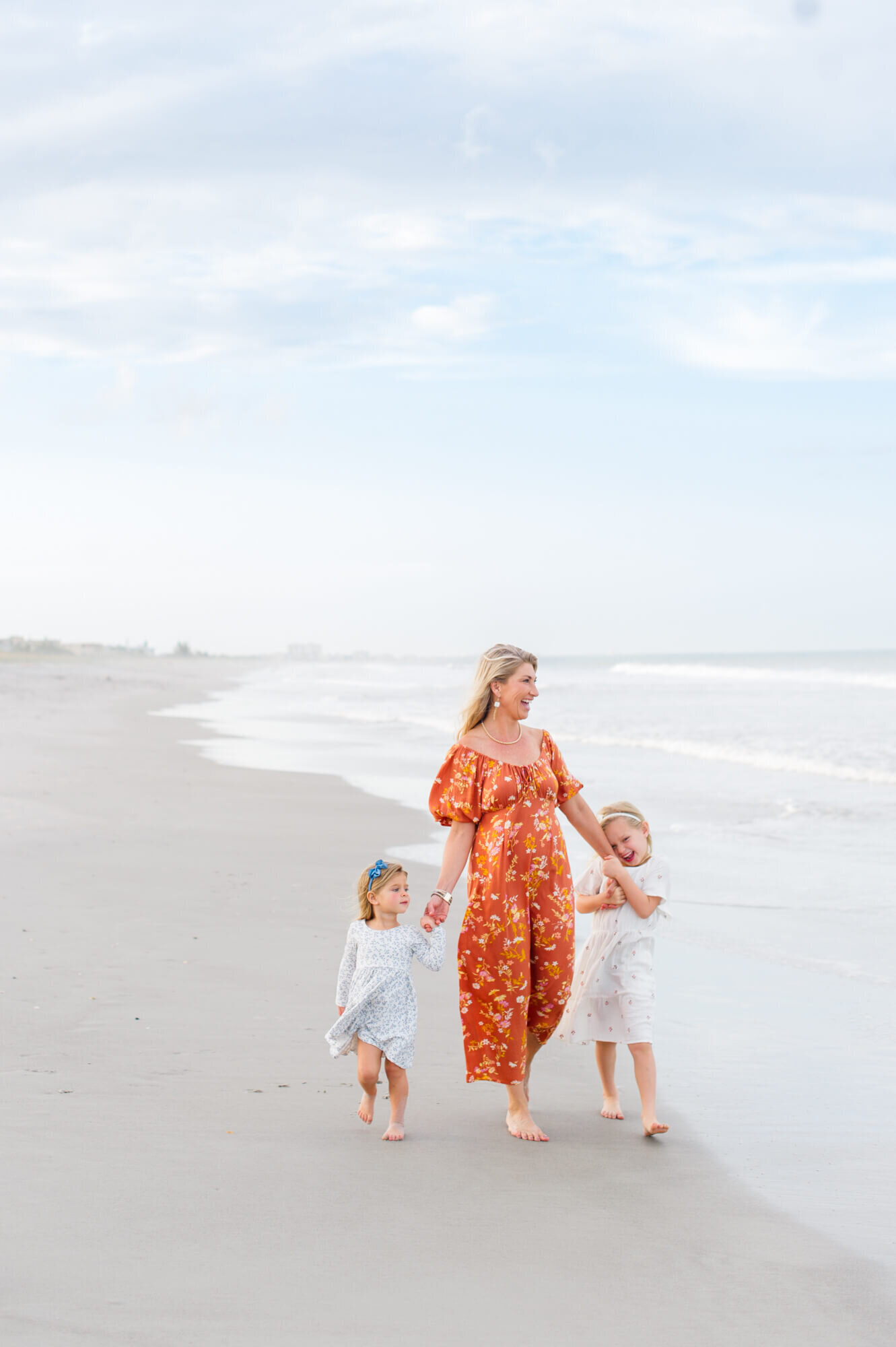 Grandma walking on the beach with her grandkids during an extended family photography session