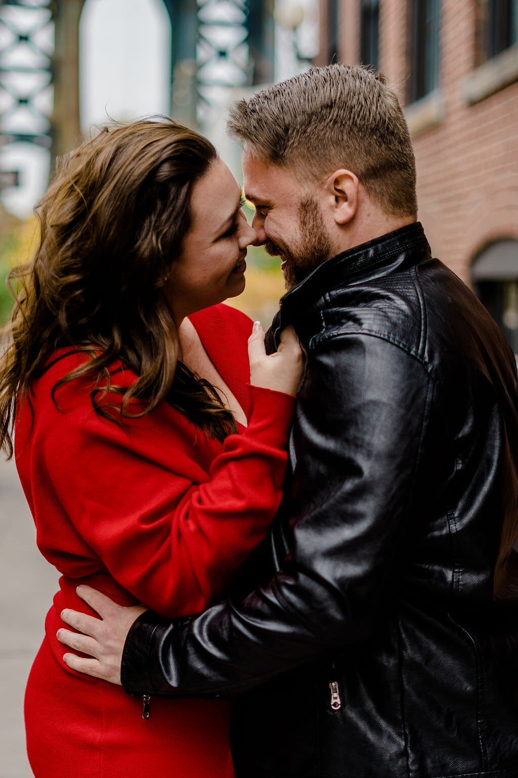 couple holding each other's jackets while they lean in for a kiss