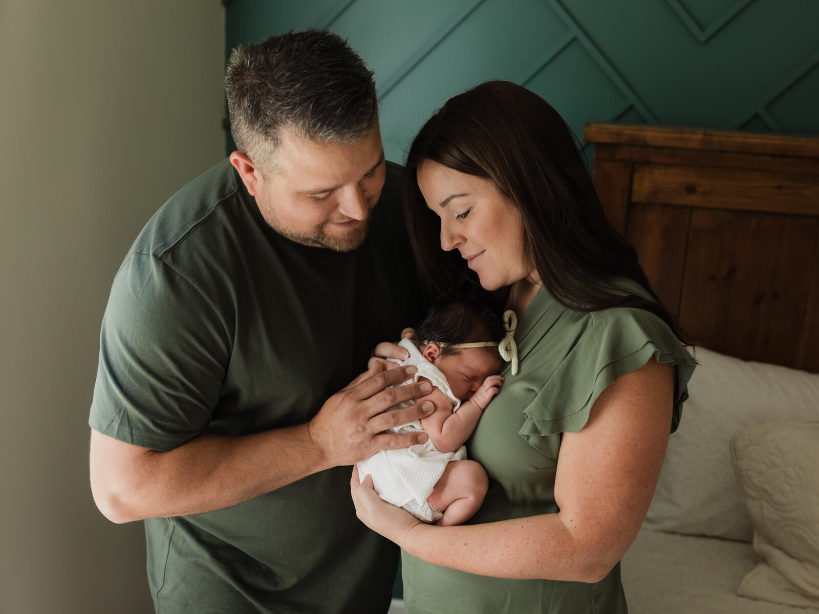 mom and dad holding newborn baby girl for in home lifestyle newborn session