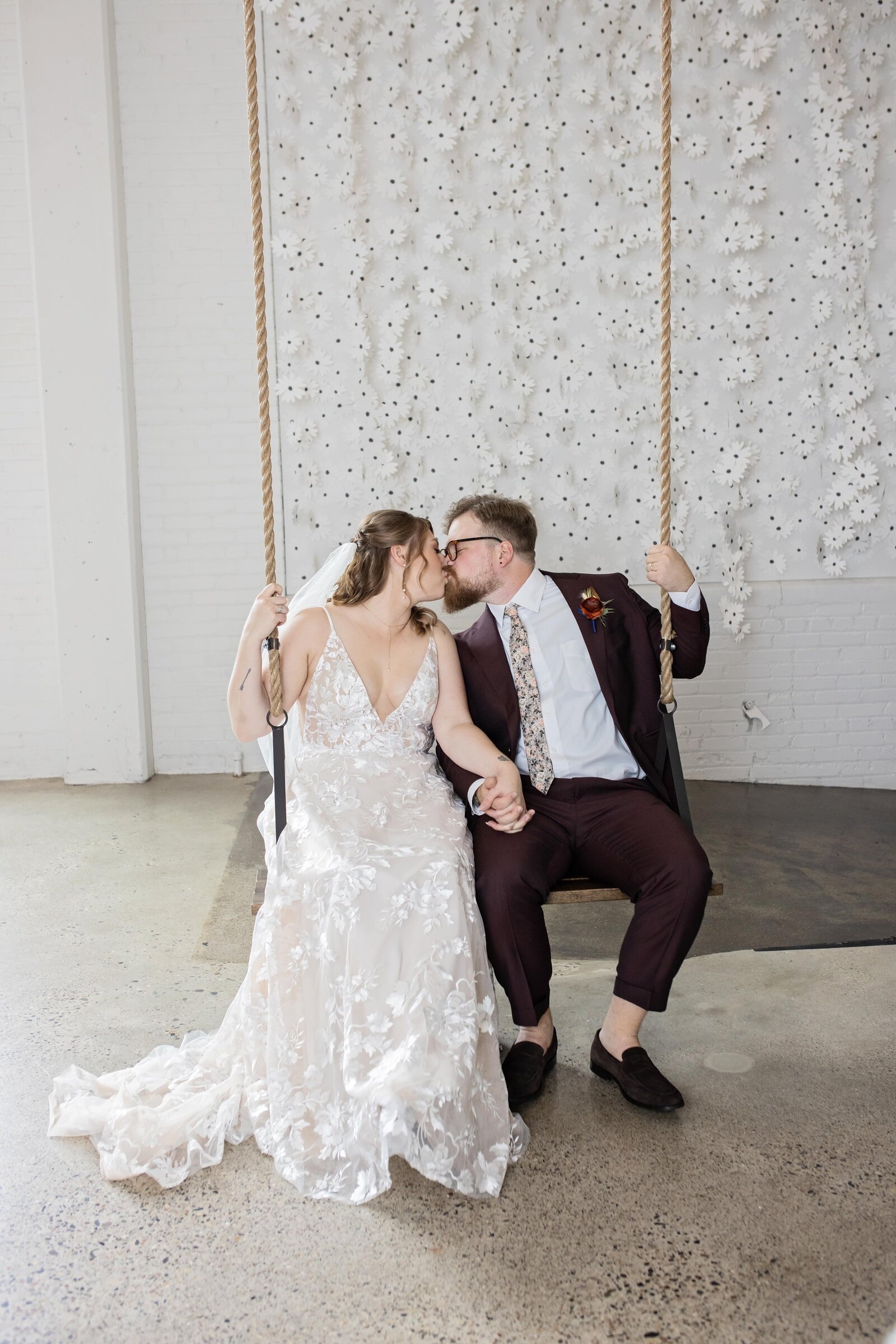 bride-groom-kissing-on-swing-urban-daisy