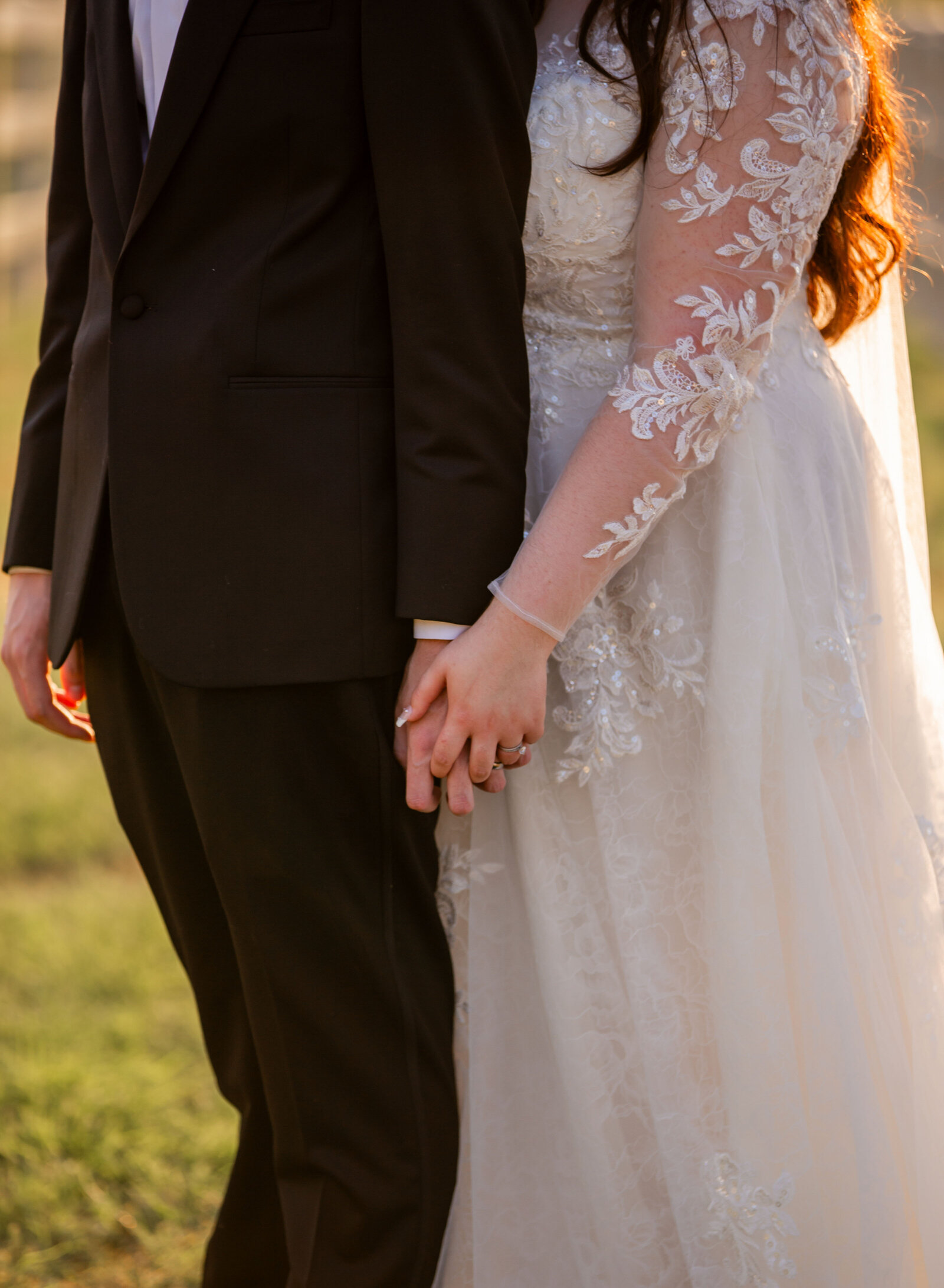 close up bride and groom holding hands