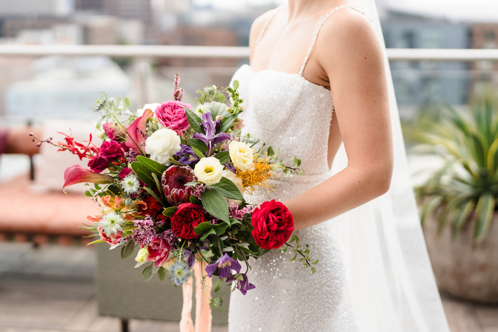 Bride holds her colorful bouquet featuring Dutch flowers
