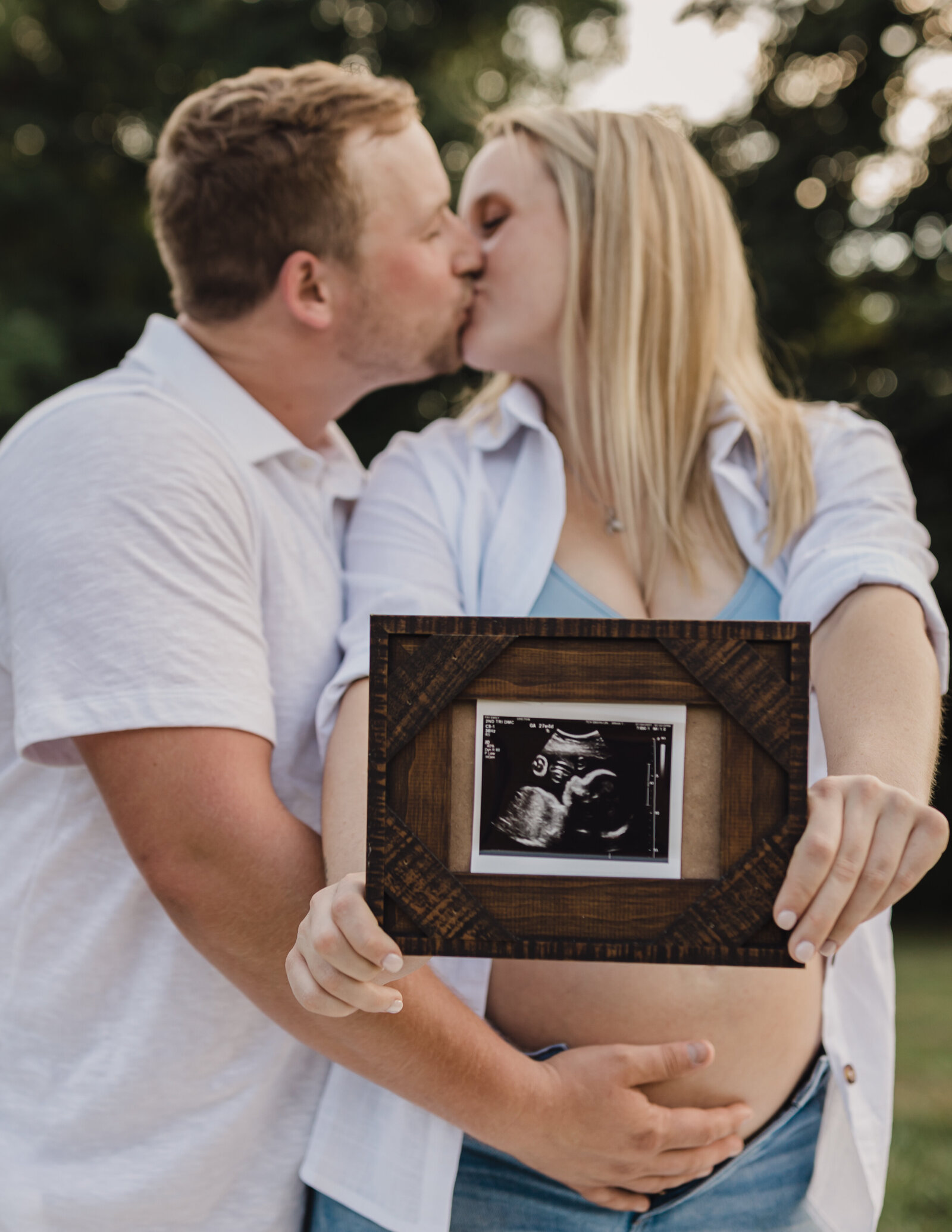 husband and wife holding ultrasound of baby for maternity photoshoot