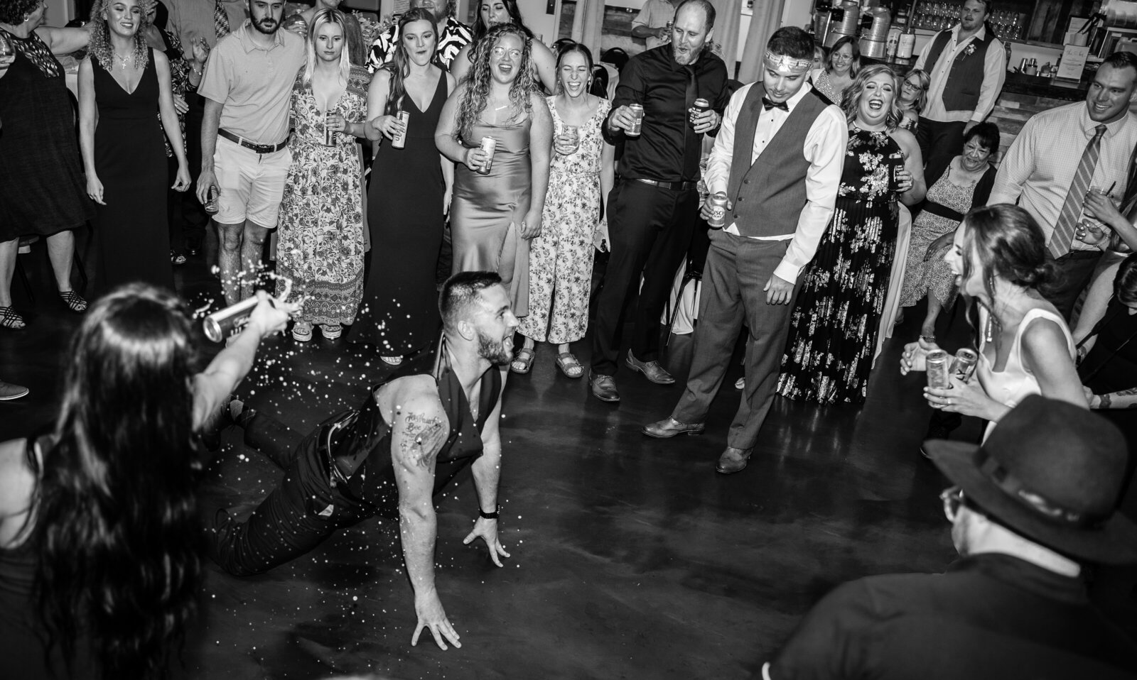 The groom, Ryan Bee, shows off his dance moves for his new wife, Mahalie, as one of their guests sprays beer on him at The Old Blue Rooster Event Center LLC in Lithopolis, Ohio.