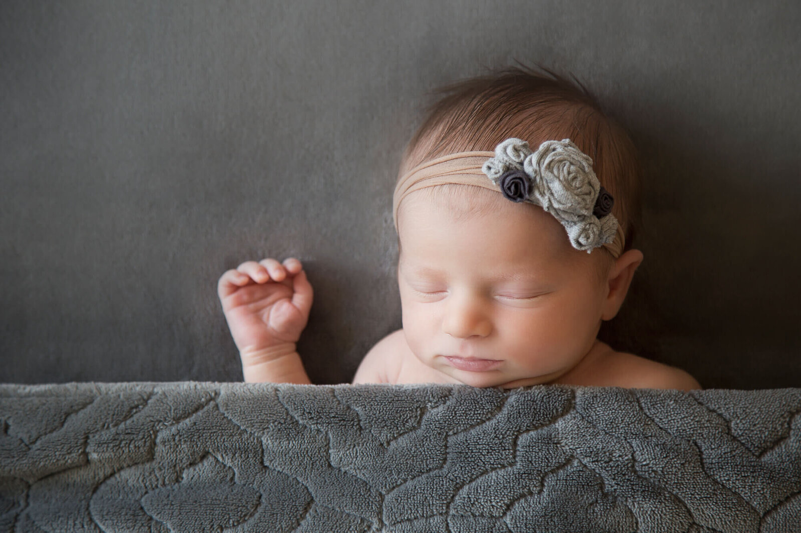 Gray blanket on sleeping newborn baby girl