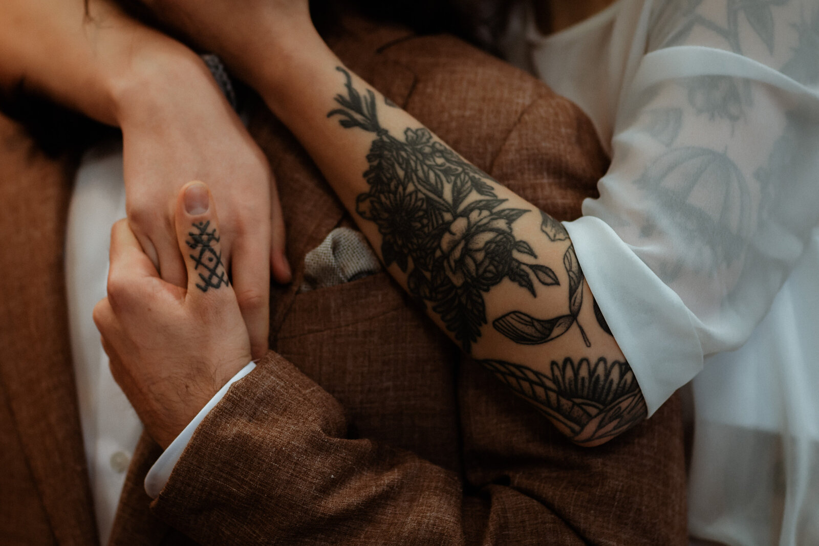 Holding hands tijdens het huwelijk van koppel met tattoos