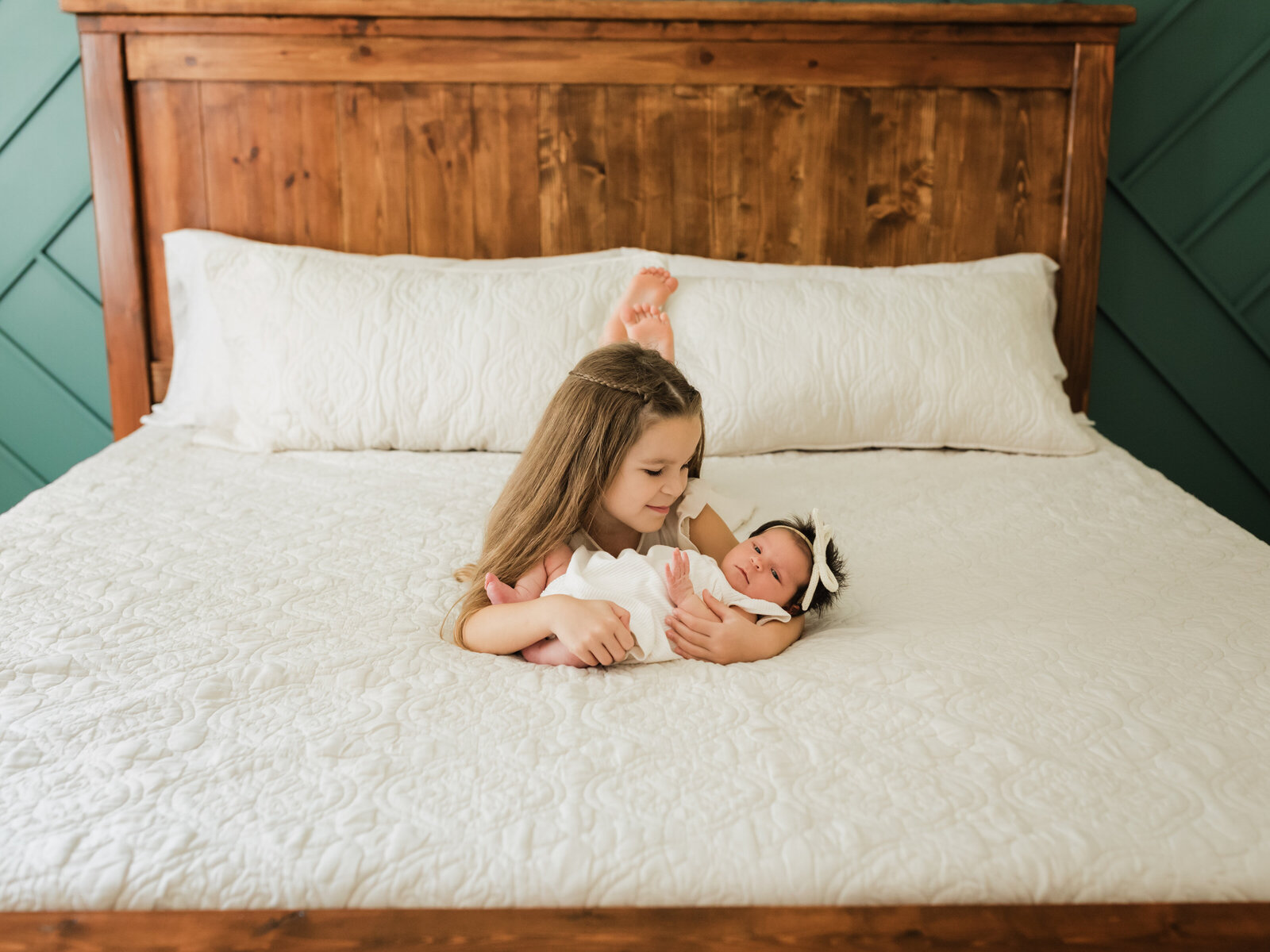 sister holding newborn baby girl for in home lifestyle session