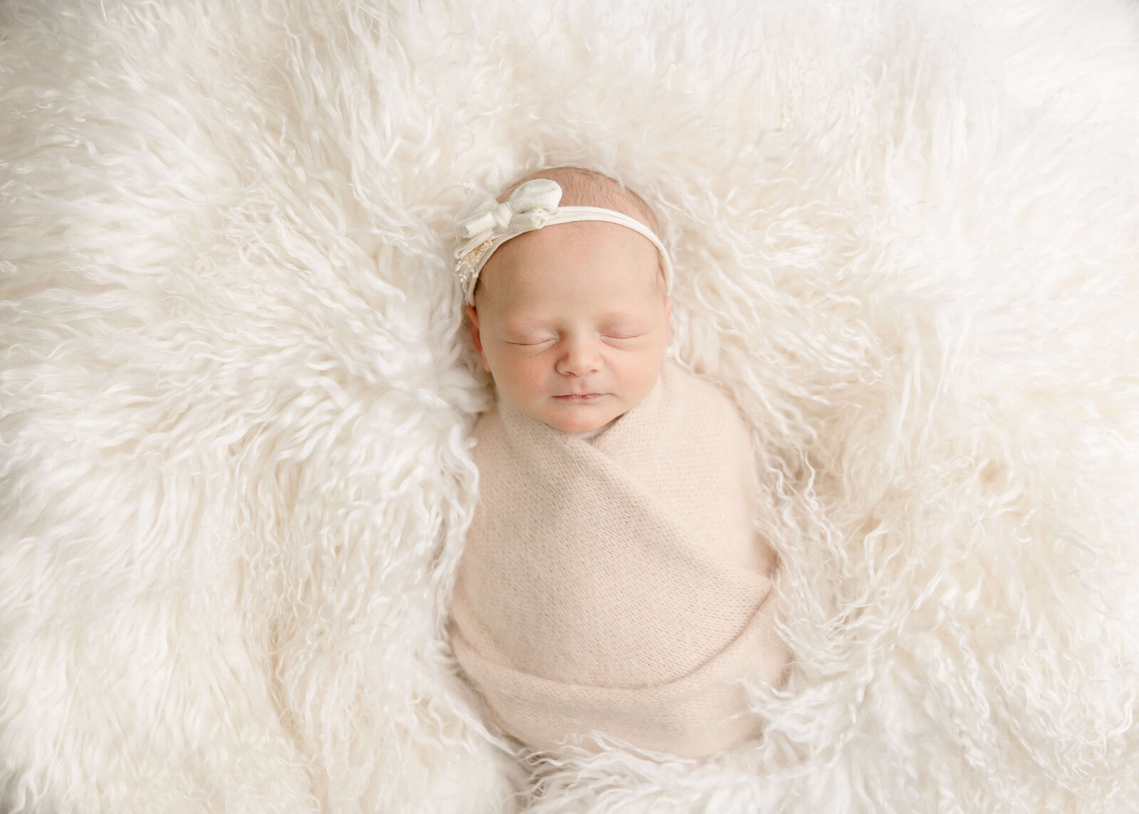 Baby girl wrapped in neutrals on bean bag sleeping by Ashley nicole.