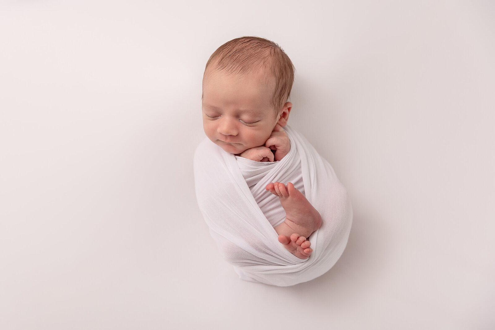 baby in white swaddle sleeping by Newborn Photography Bucks County PA