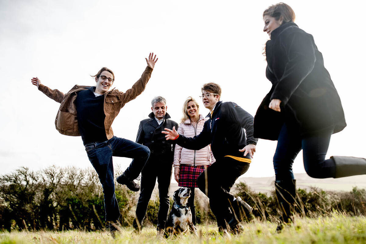 children running past mum and dad, as dog sits at feet