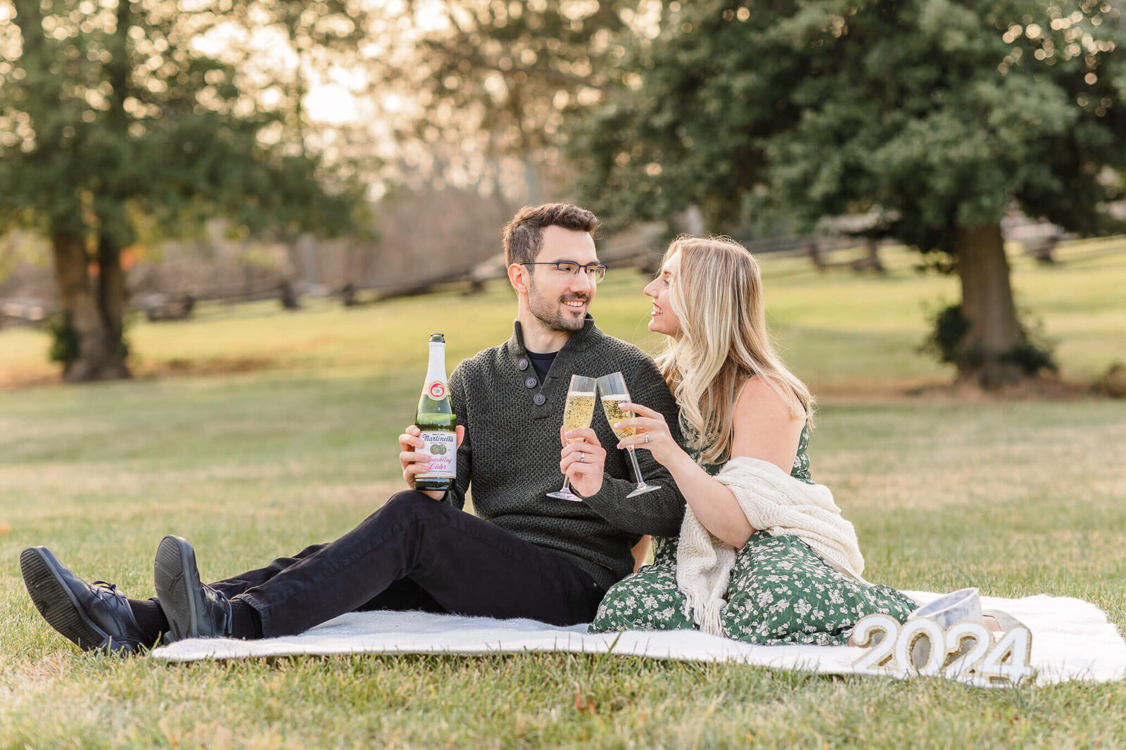 A couple at their pregnancy announcement session at a park at sunset.