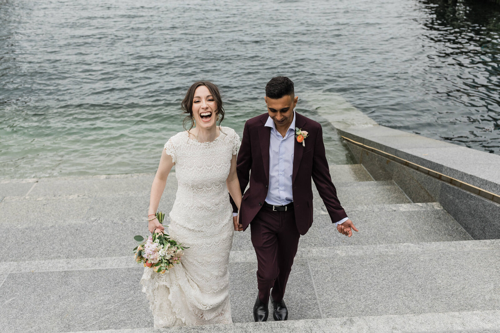 Couple laughing on the steps at Muir at Halifax waterfront.