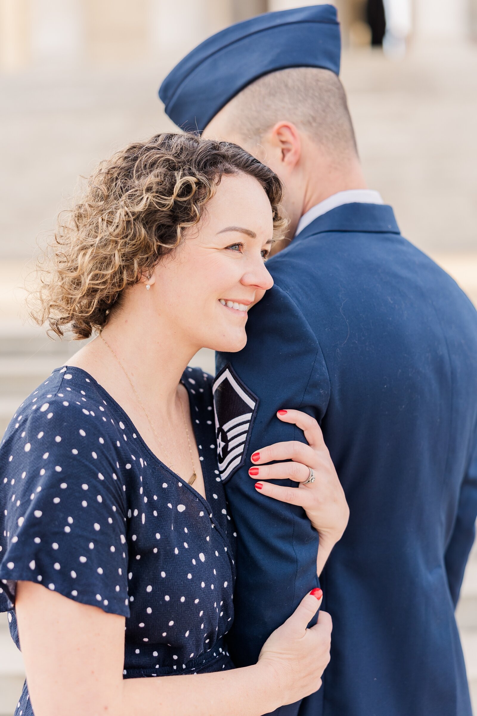 Air Force wife holding her husband's arm and looking into the distance