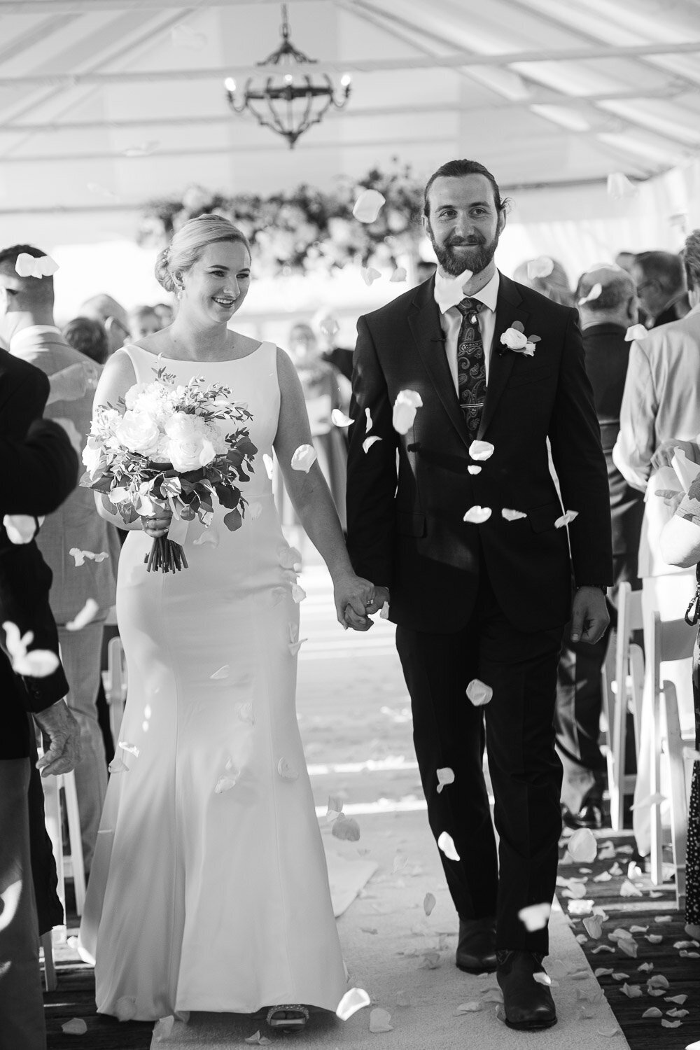 couple down aisle with petals