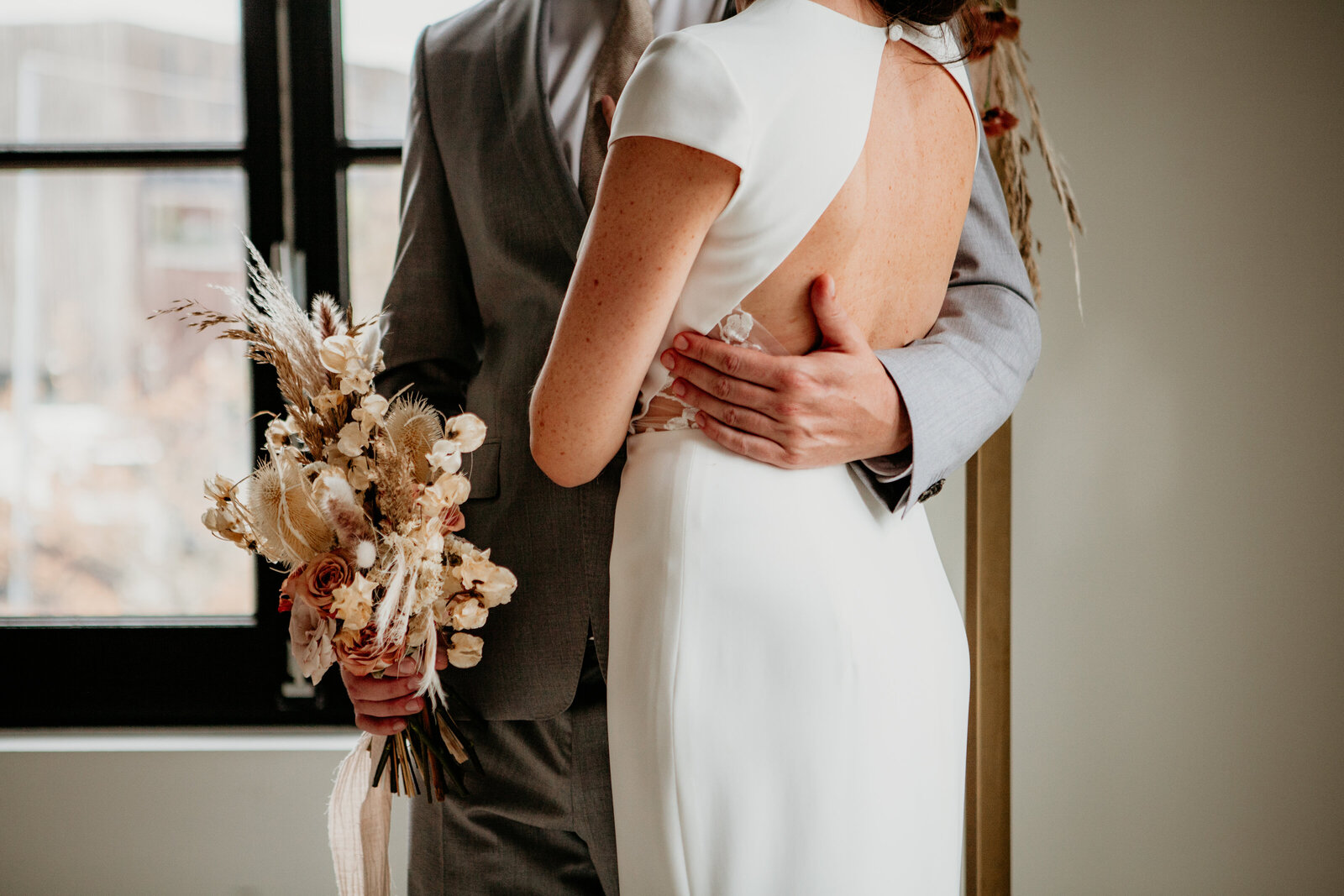 Huwelijk koppel tijdens trouwceremonie met boeket in hand