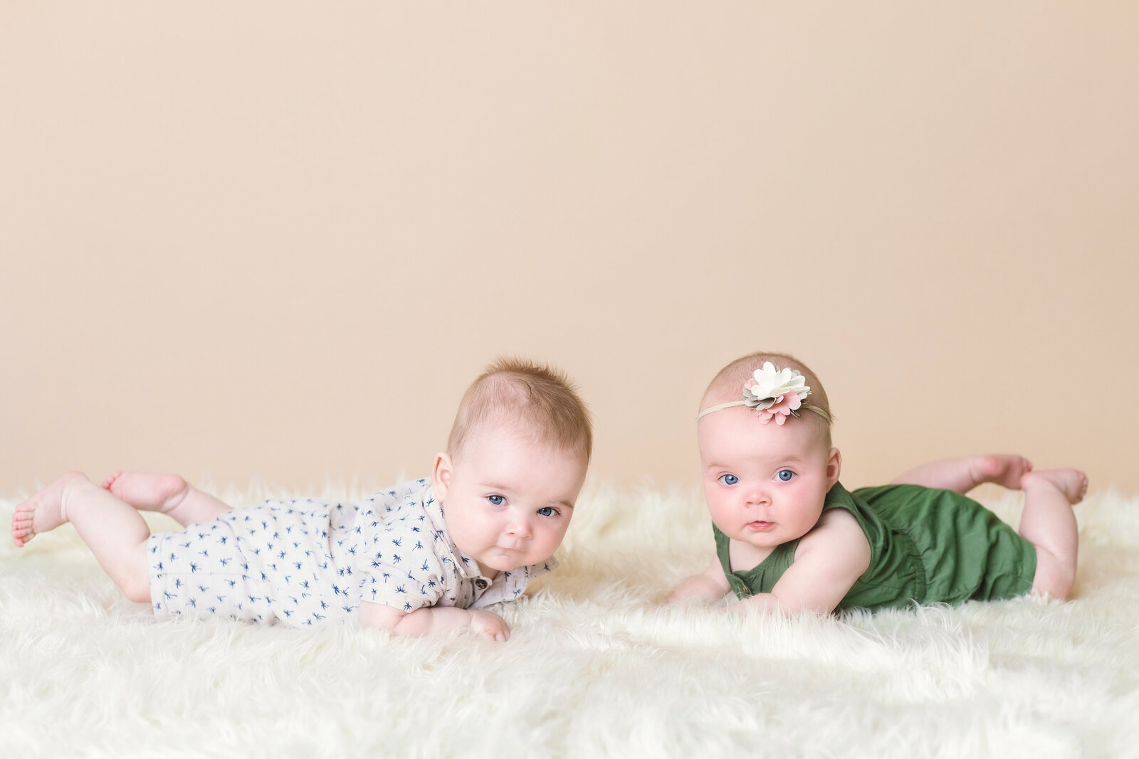 Milestone Photographer, two baby girls lay on white shag carpet