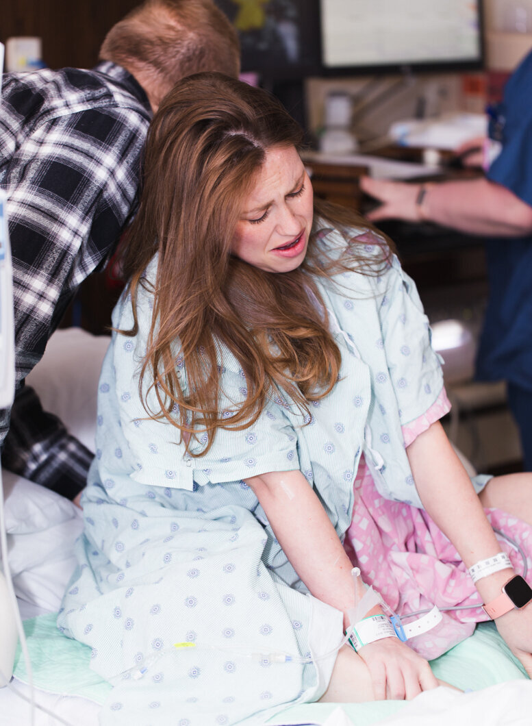 A mother labors on her knees in the hospital. Birth story photos by Diane Owen.