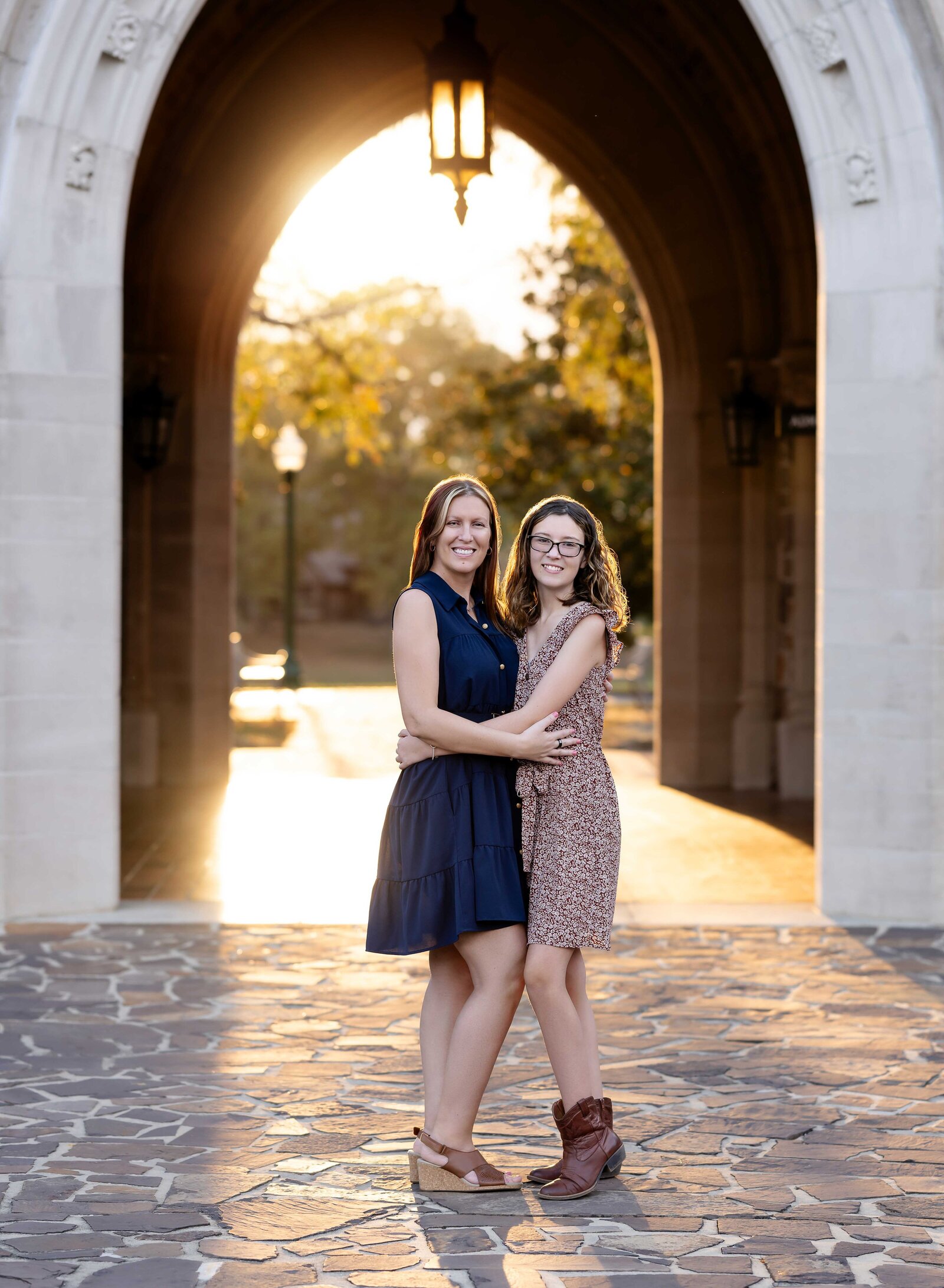 Mother and daughter standing under arch at Berry College and hugging for photo. Family Photography by Jenni Nikki Photography- Atlanta Family Photographer.
