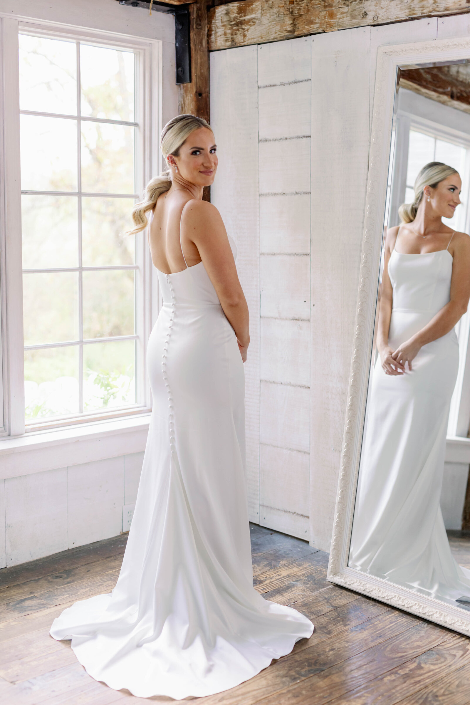 Bride admiring herself in wedding gown in mirror