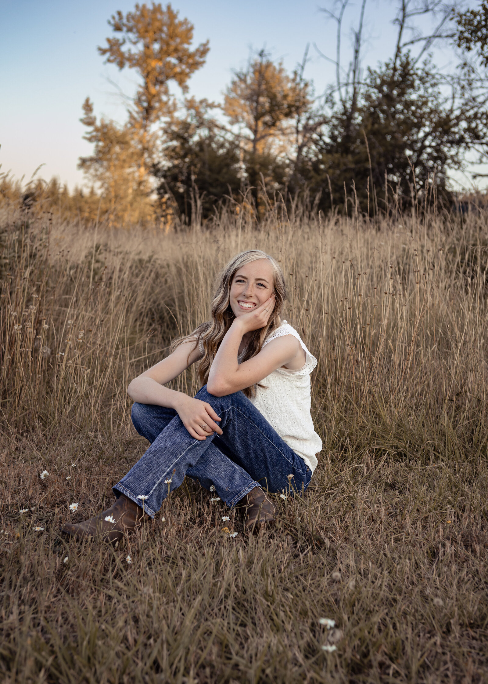 Girl sitting in field at Milo Mciver Park for Senior Portraits