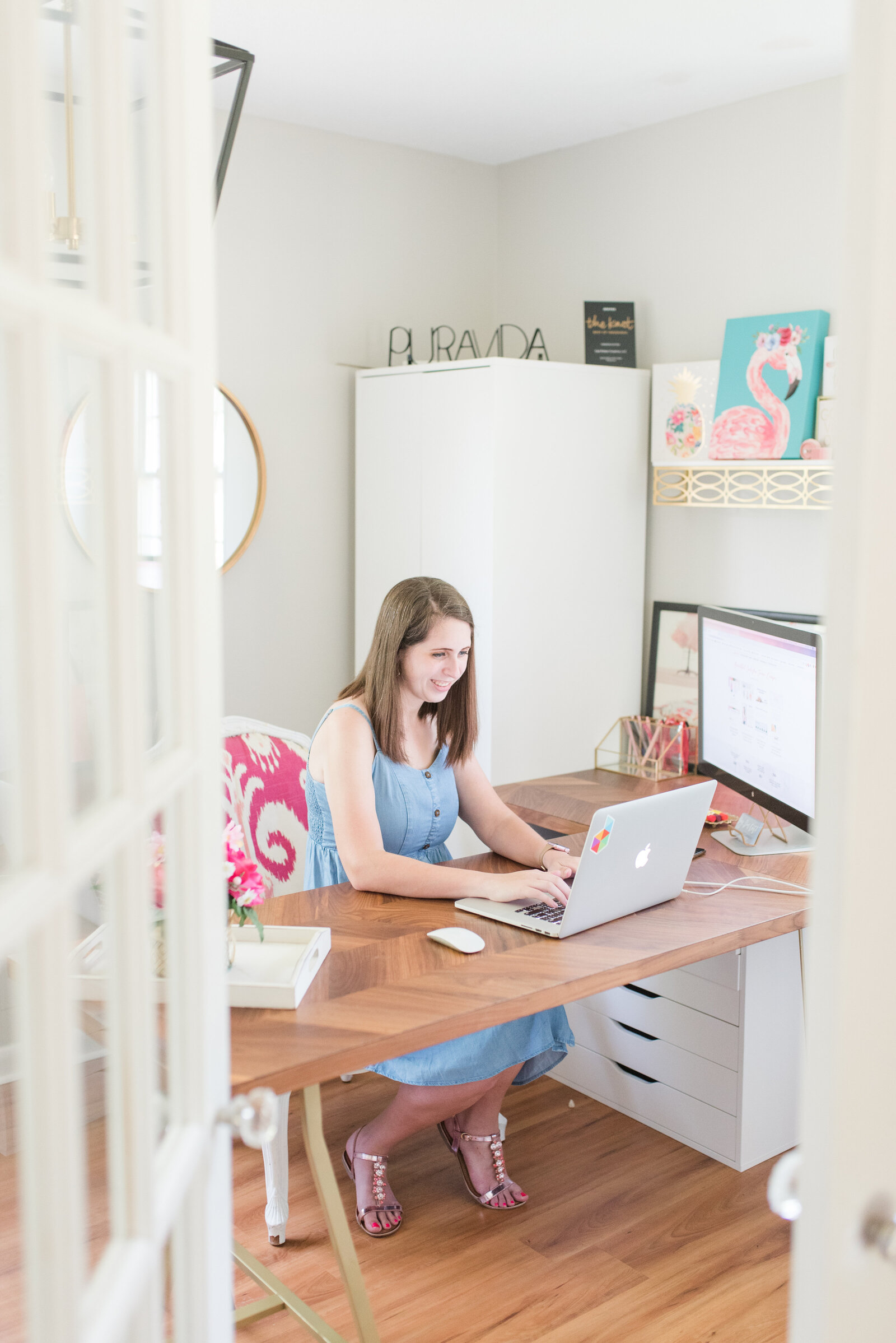 Cait Potter working on a laptop at her desk in a bright home office