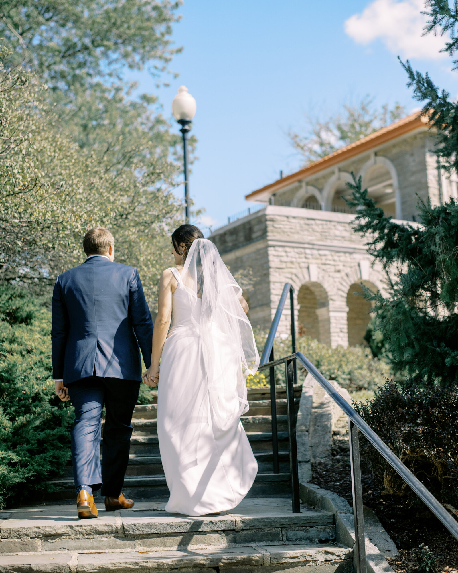 bride and groom walk up steps