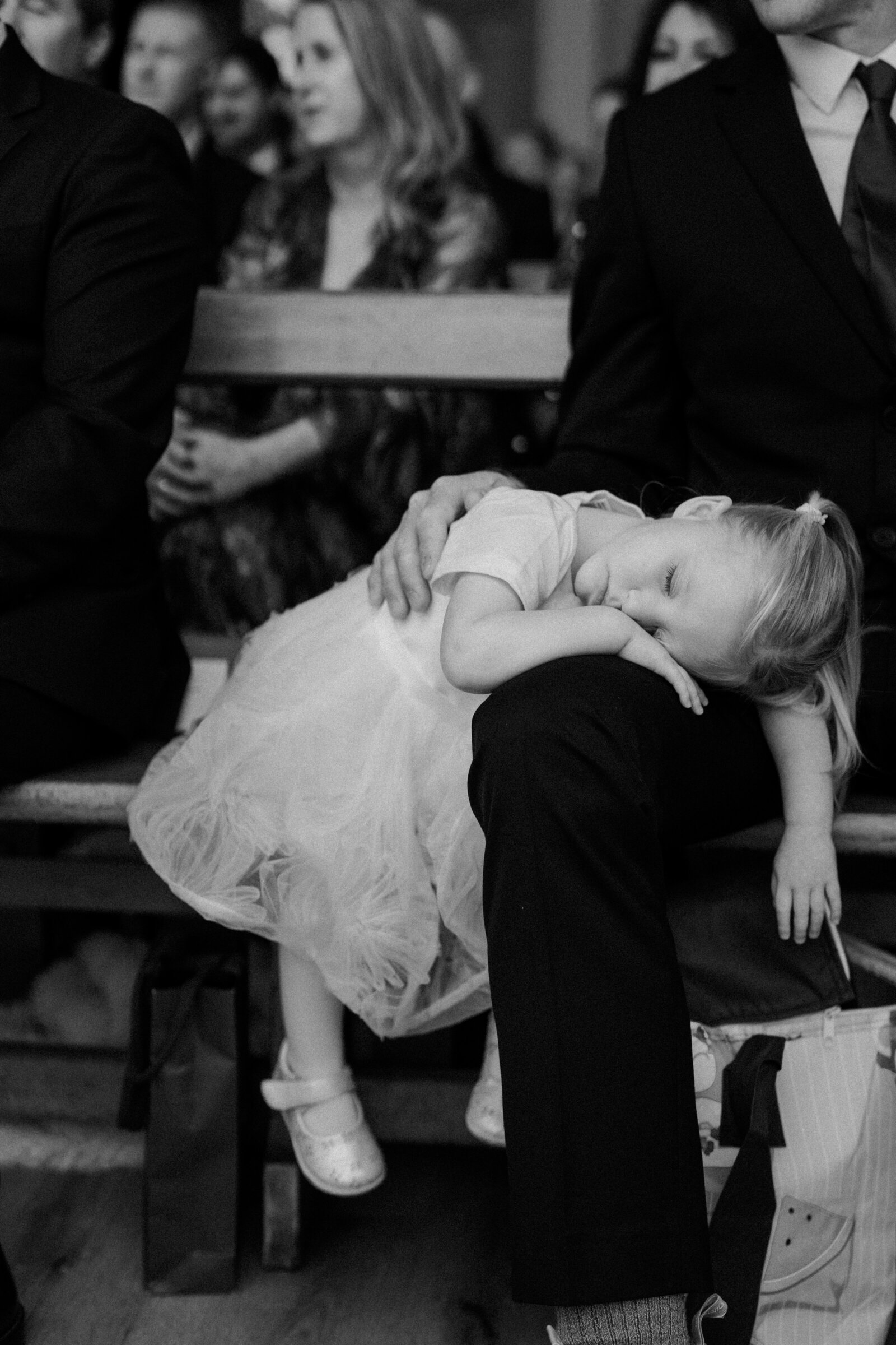 Young girl asleep on dads lap during ceremony