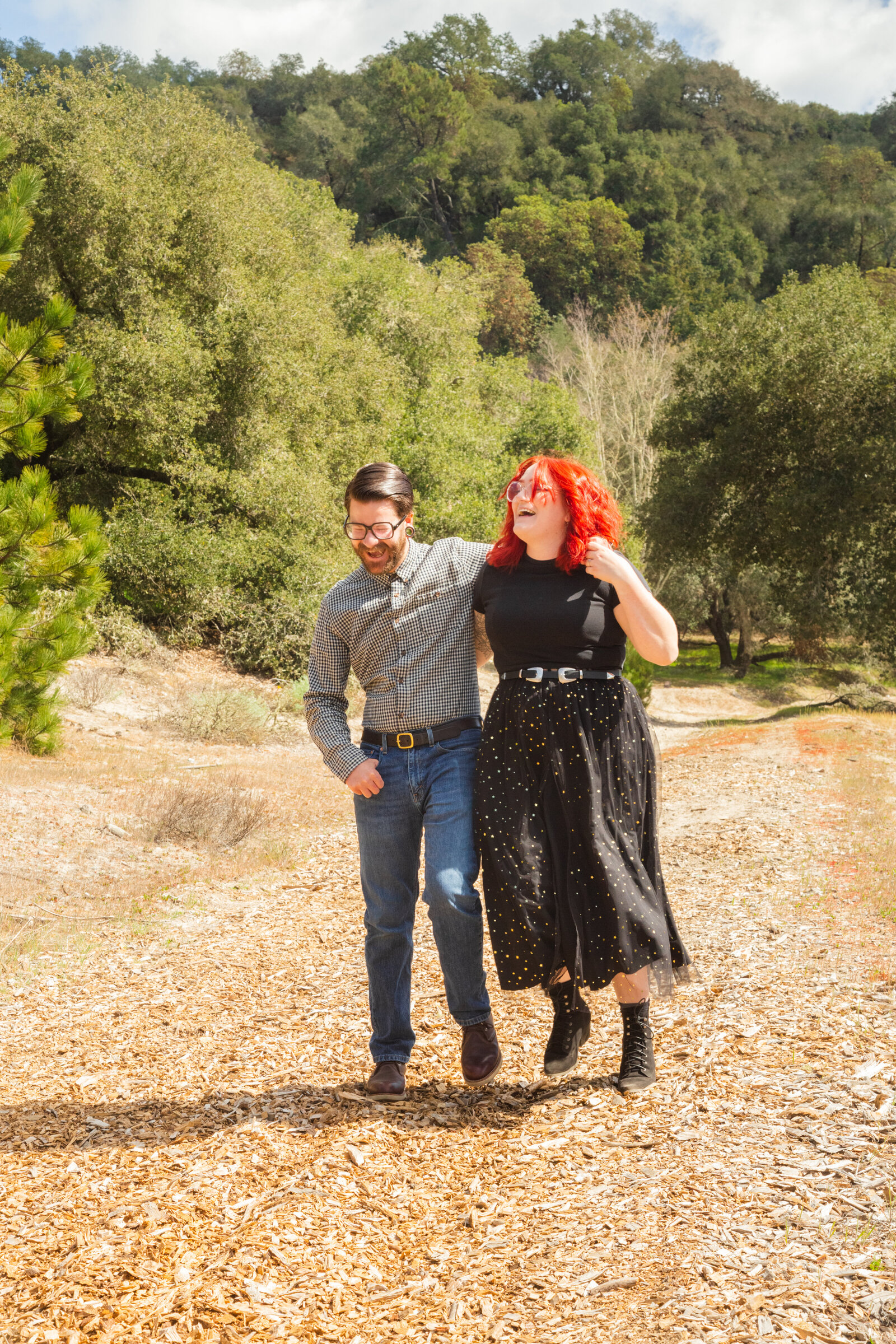 An tattooed engaged couple poses for photos in a redwood forest in Santa Cruz, Ca.